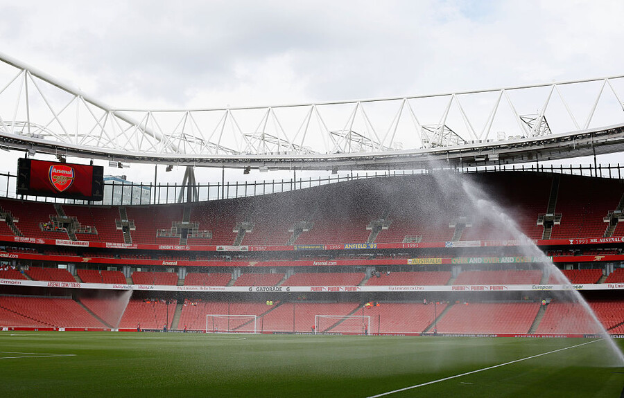 The Emirates football stadium, empty, with sprinklers running.