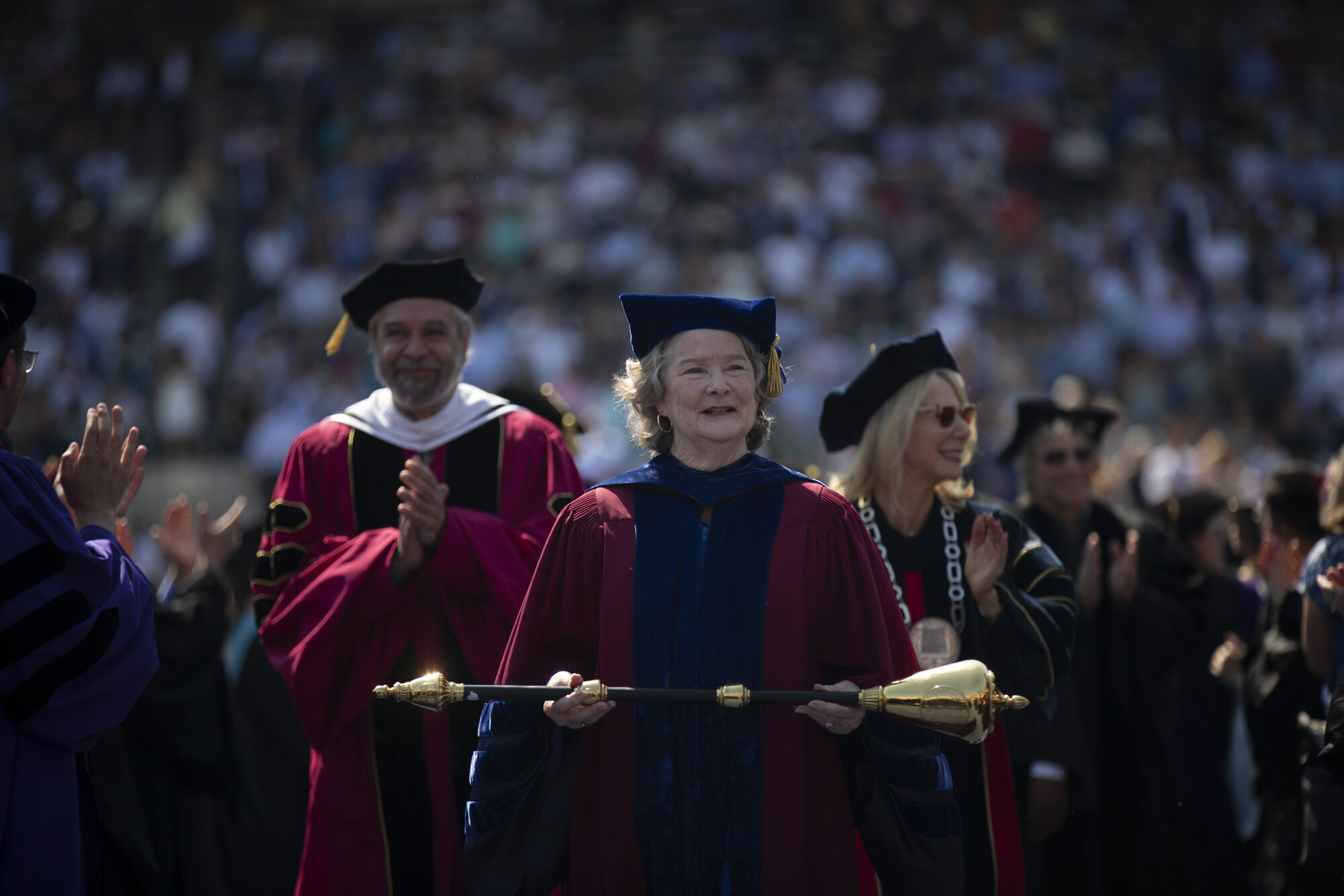 Leslie Kruhly carrying a mace in procession during commencement.