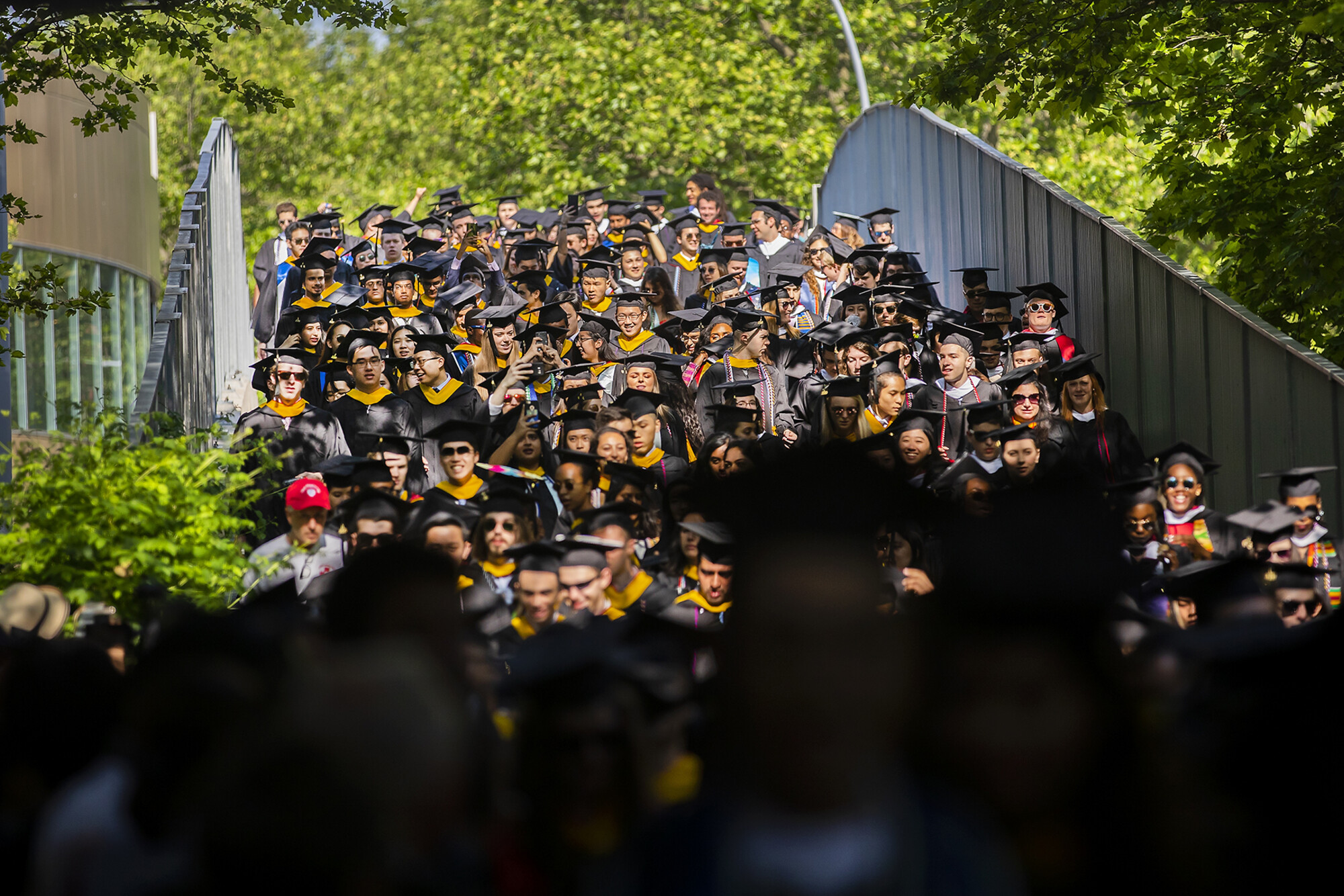 Procession of graduates down Locust Walk Bridge.