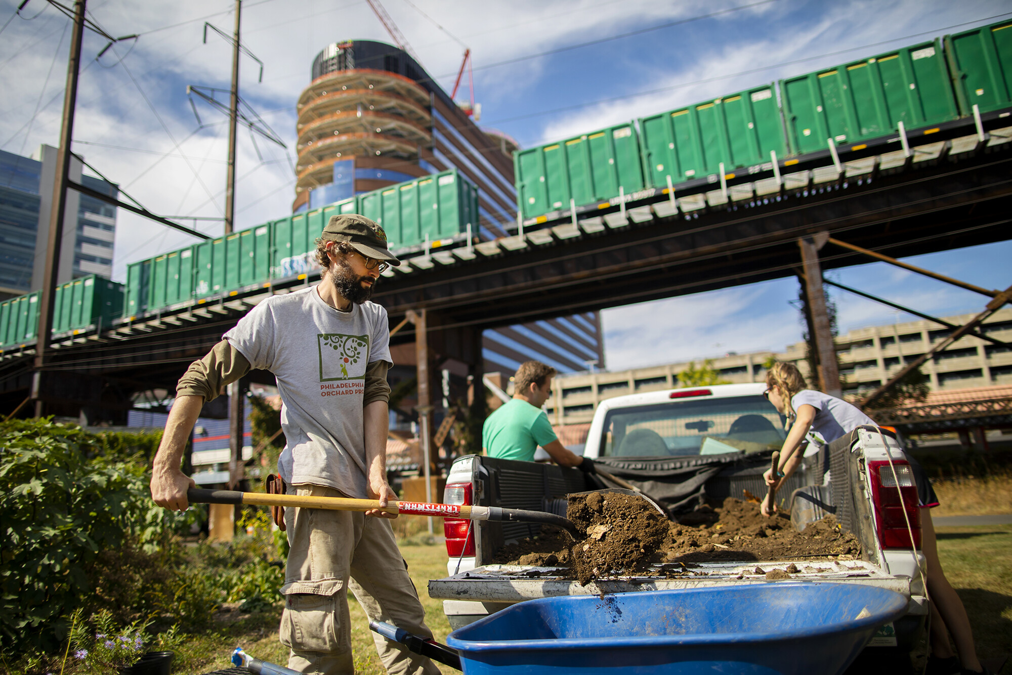 shoveling dirt from a wheelbarrow at the penn park orchard