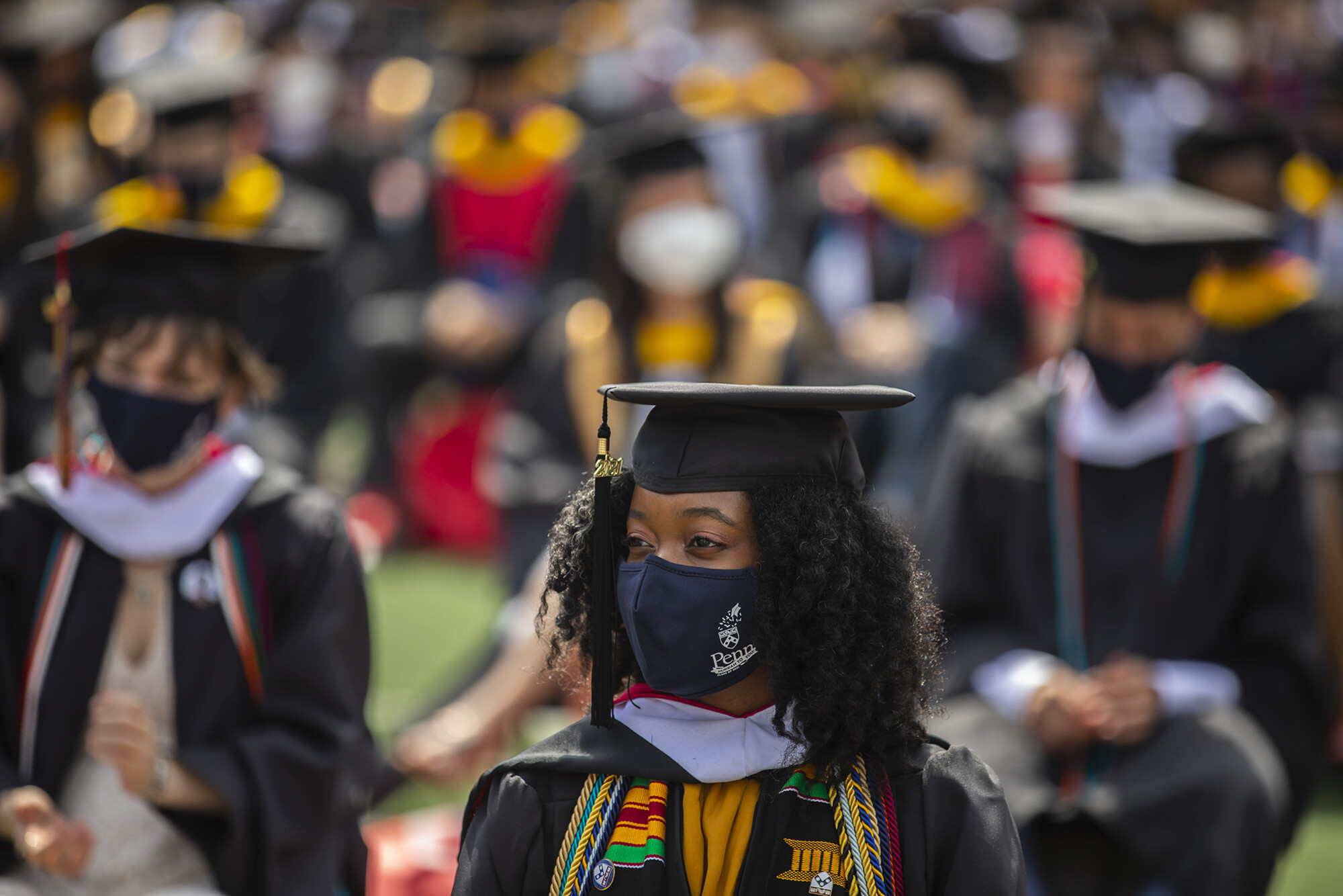 graduate sitting on field