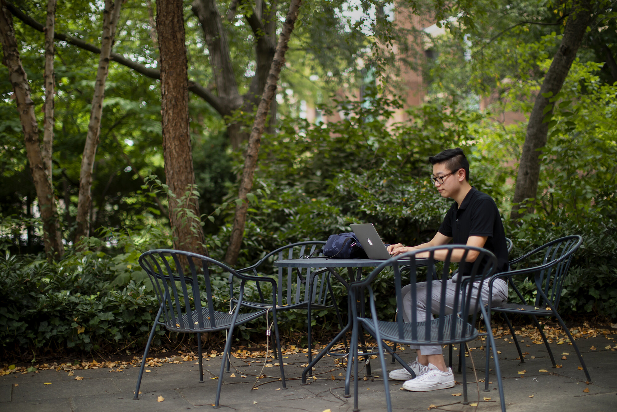 side view of steven chen working at a table