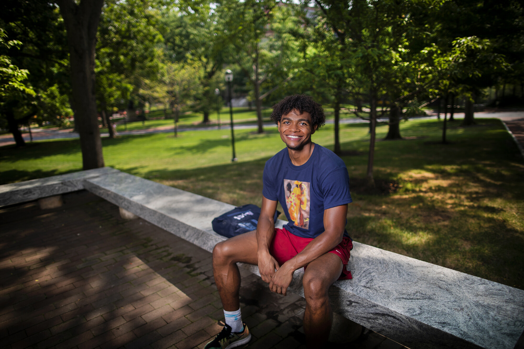 lucas monroe sitting on a bench smiling