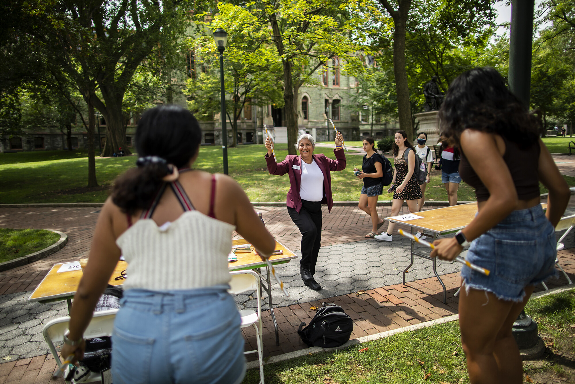 person dancing with sticks outside on walkway