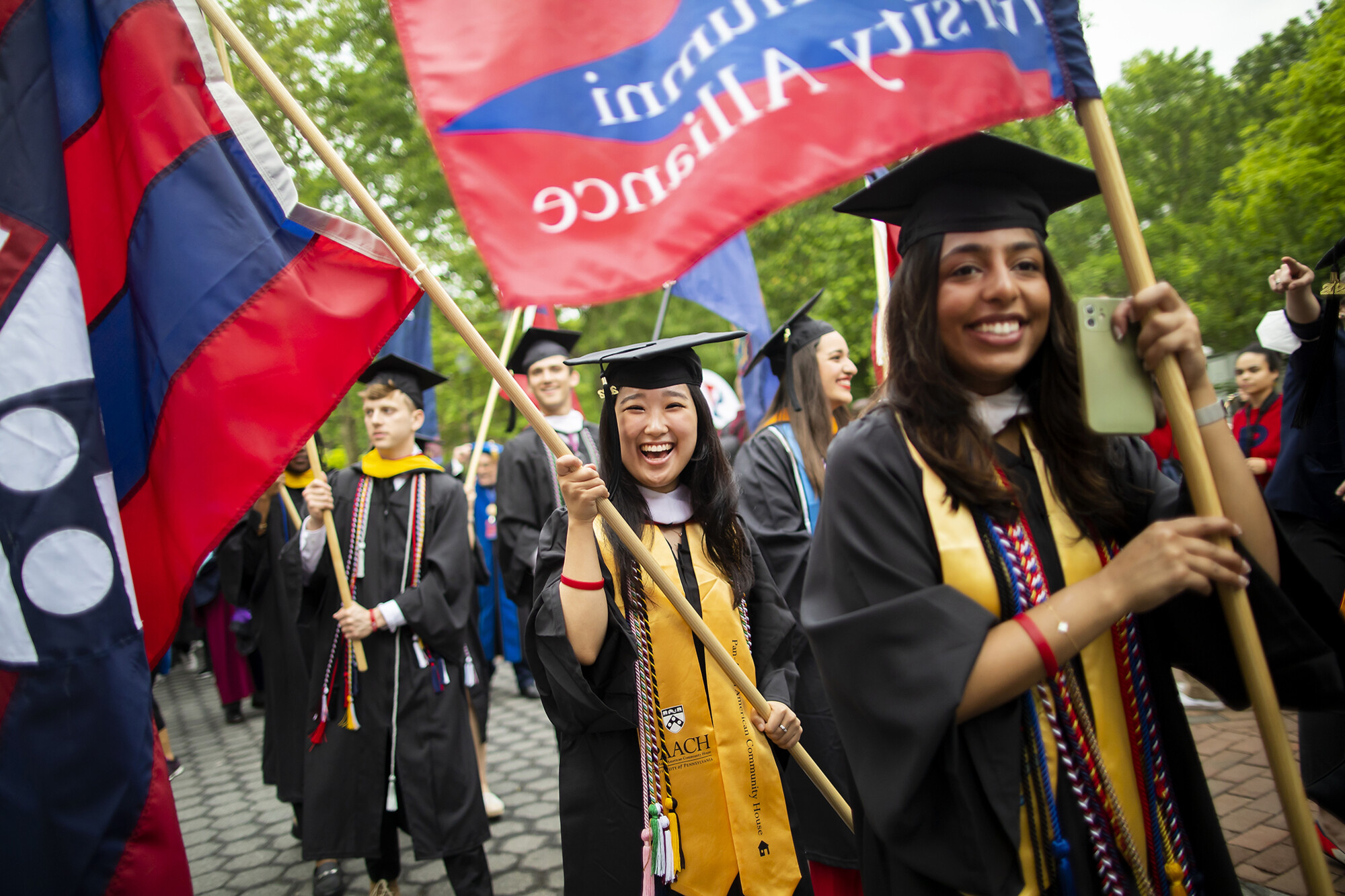 graduates with flags on locust walk