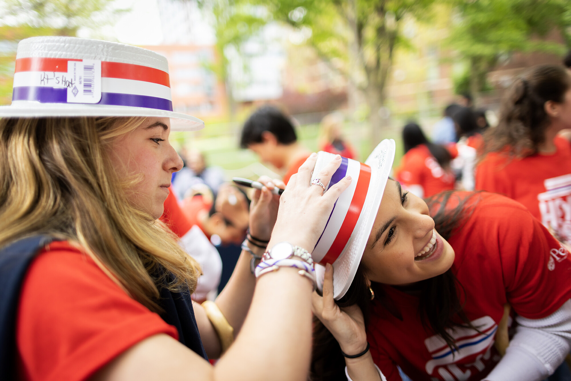 students sign hats at hey day