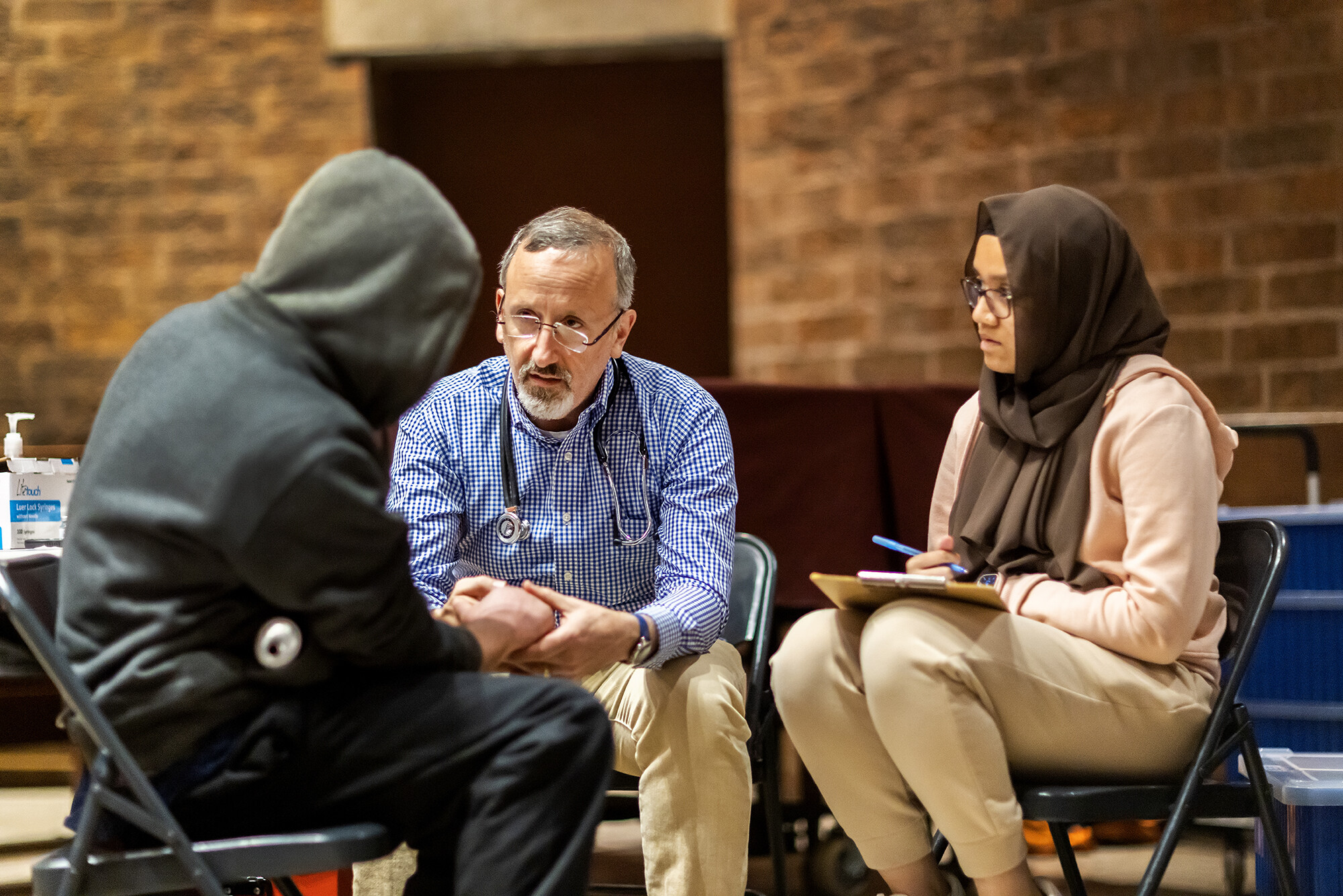 shelter health physician with patient giving consult