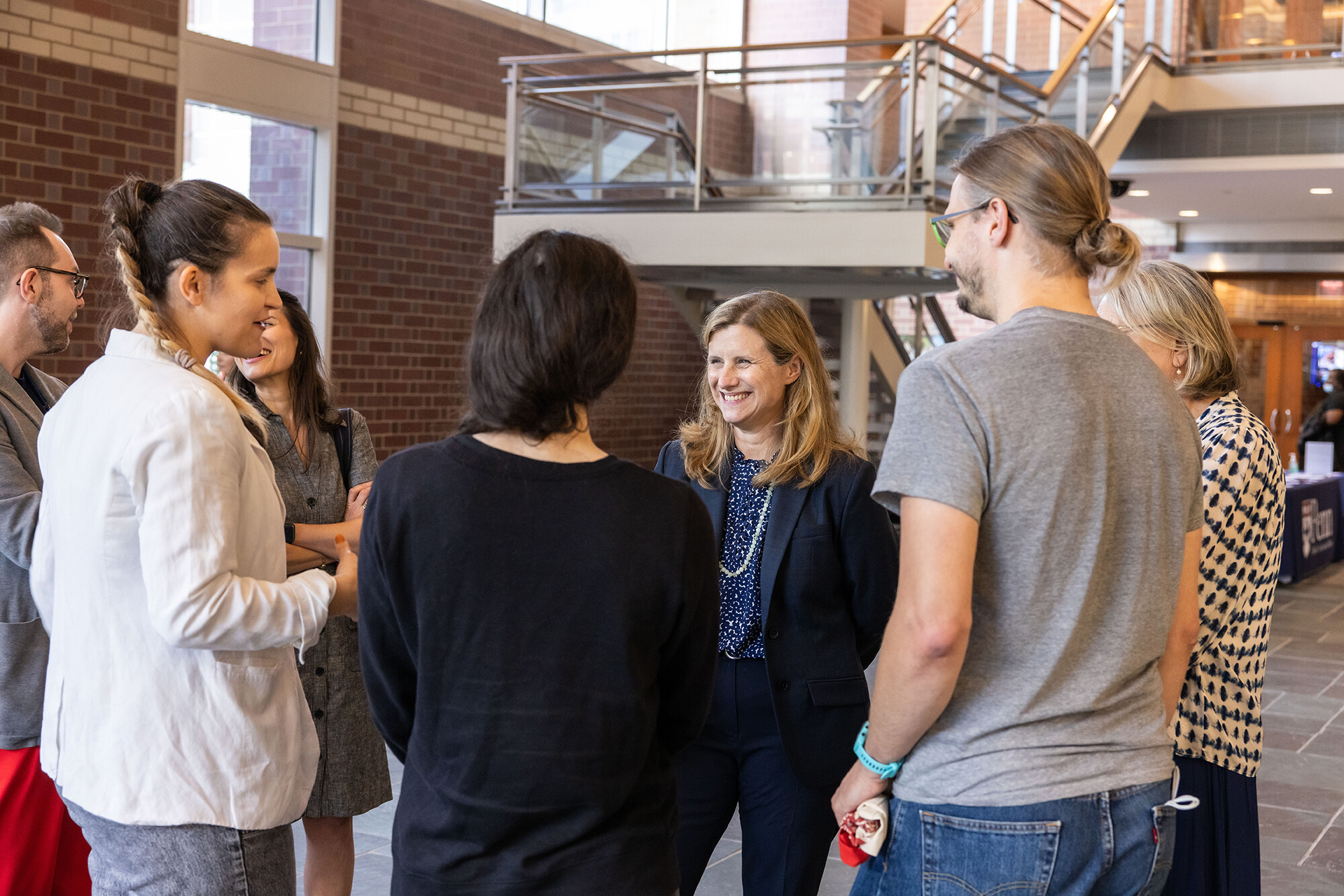 Liz Magill smiles, chatting with postdocs