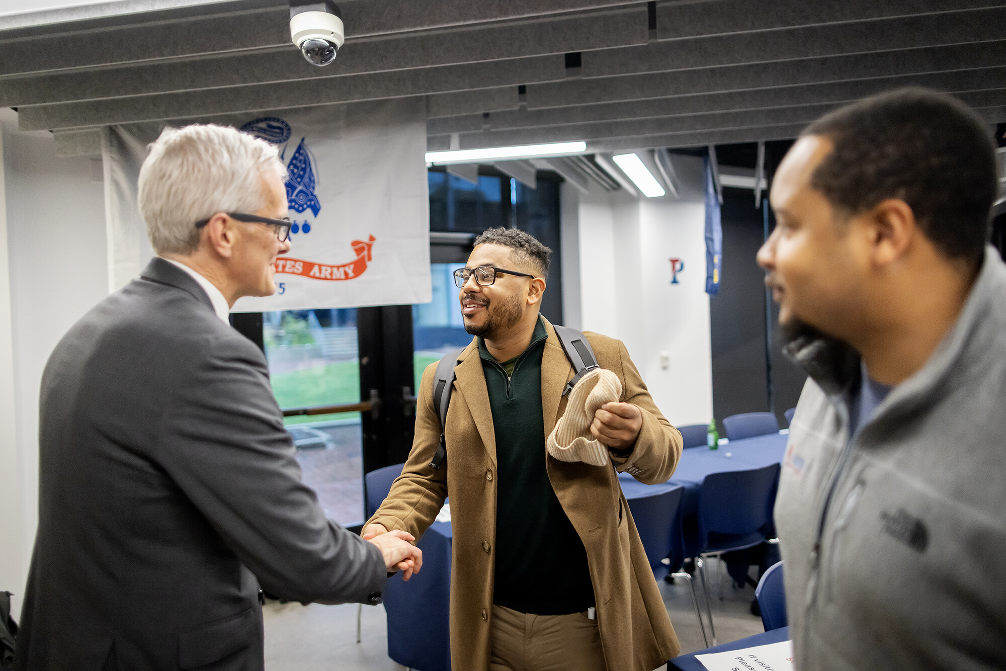 Secretary shakes hand with Penn student