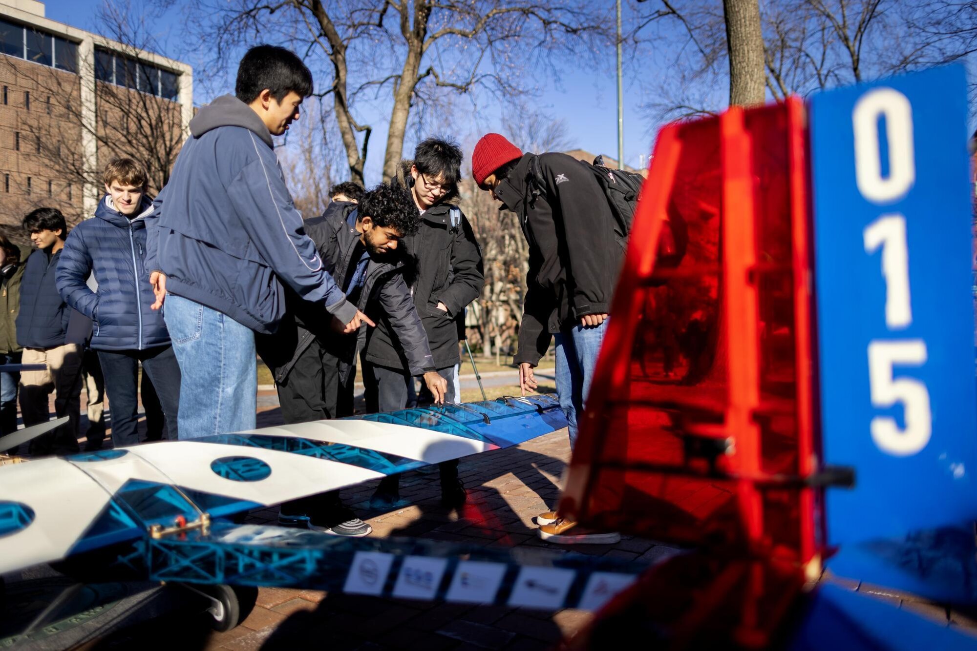 Penn’s aerial drone plane on Locust Walk in front of Van Pelt Library with students.