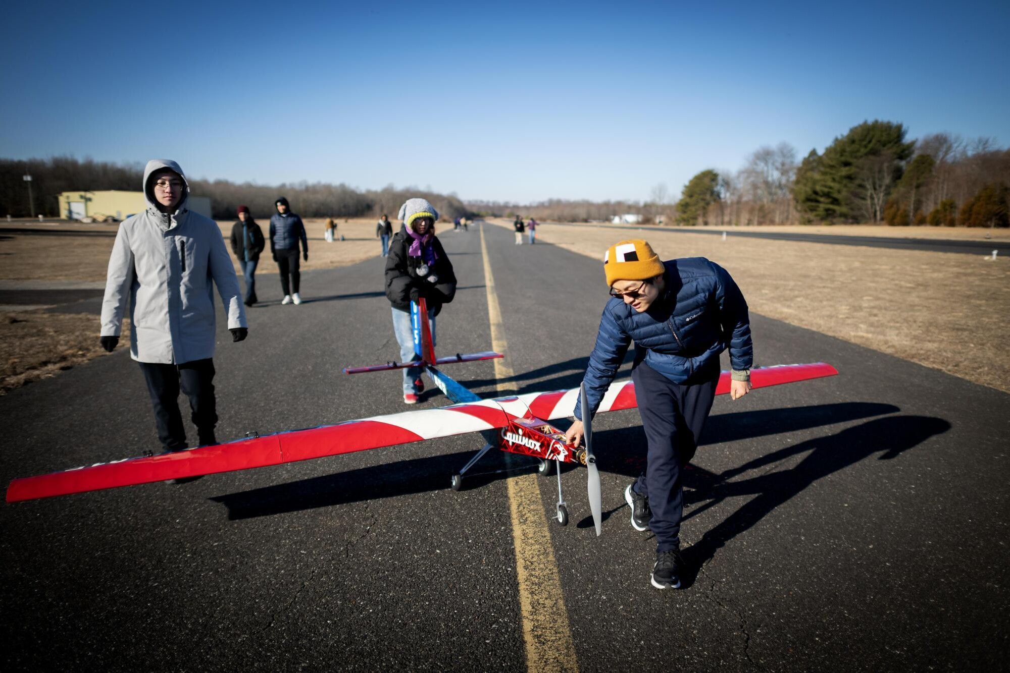 Penn students on a runway with Penn’s aerial drone plane.