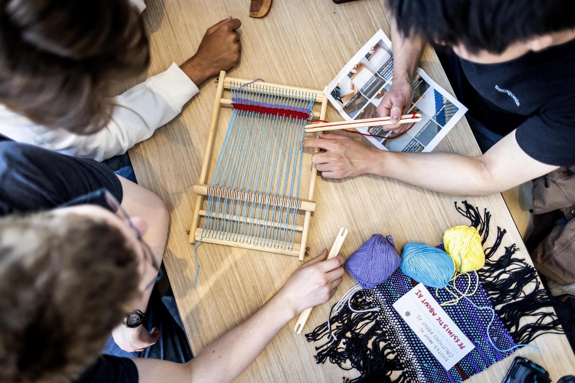 Overhead shot of students working at small loom.