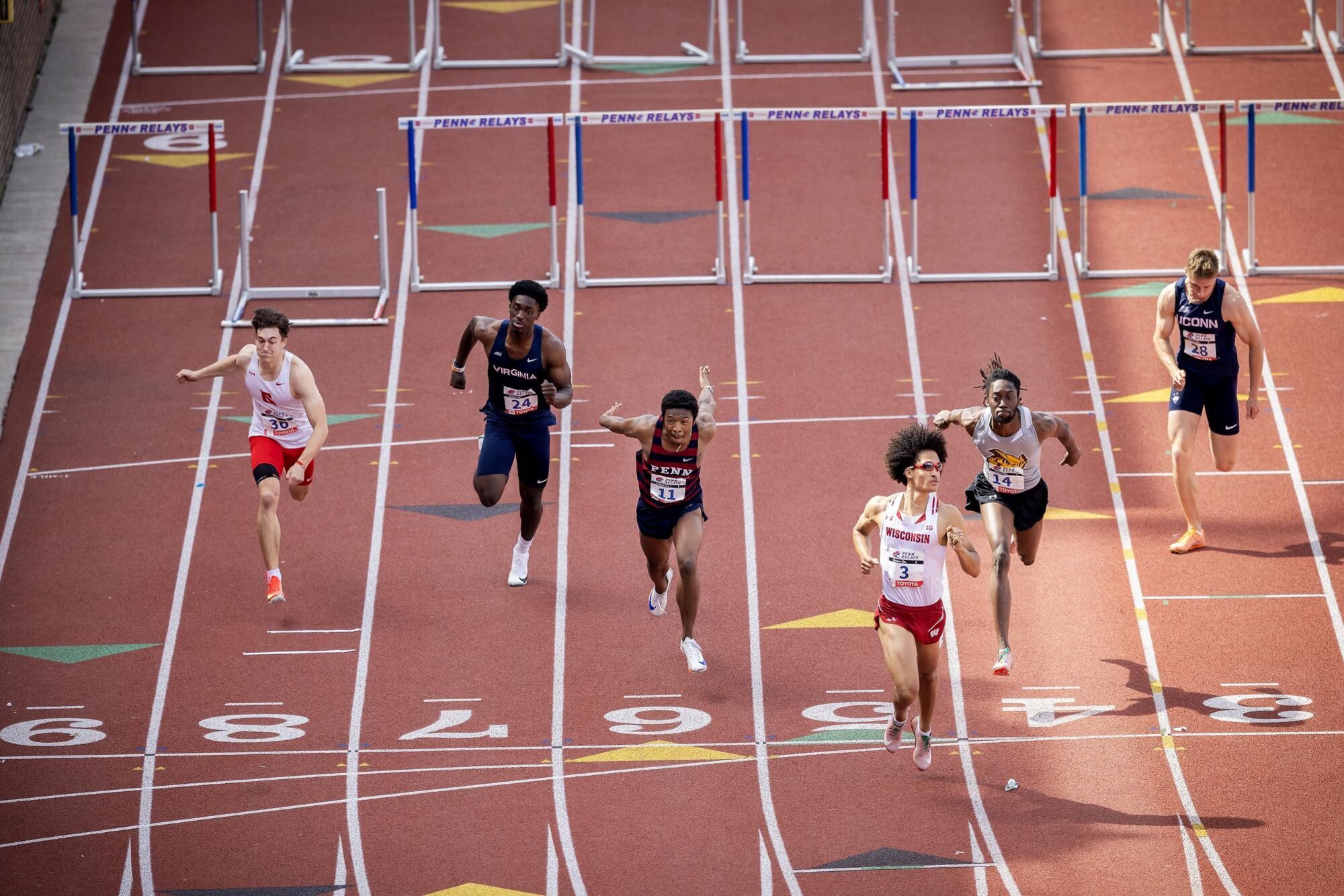 Runners after jumping over hurdles at the Penn Relays.