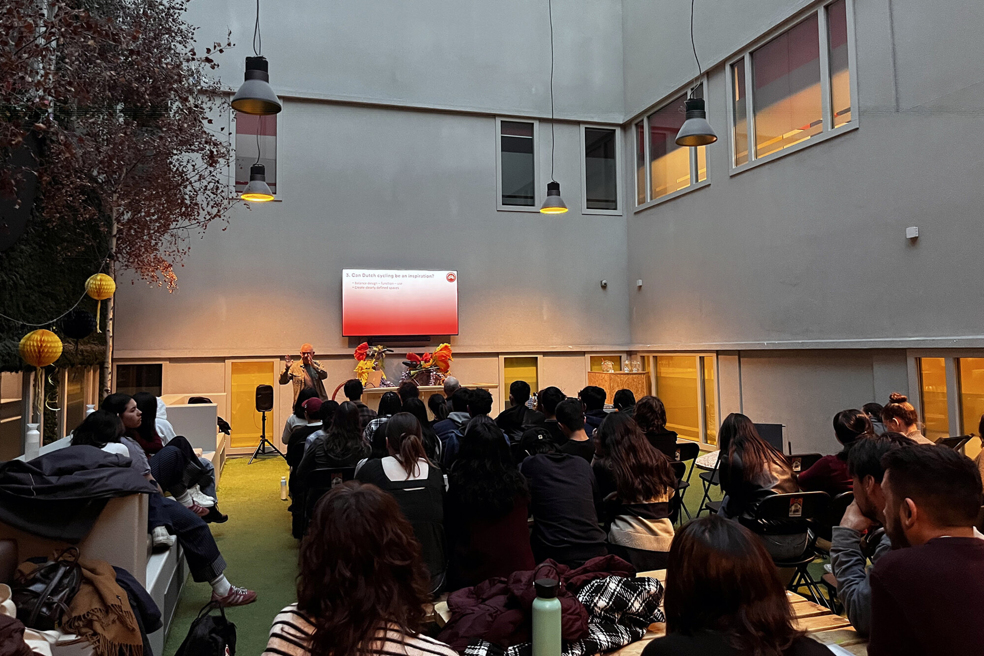 Students listening to a speaker in a presentation about bicycling in Delft.