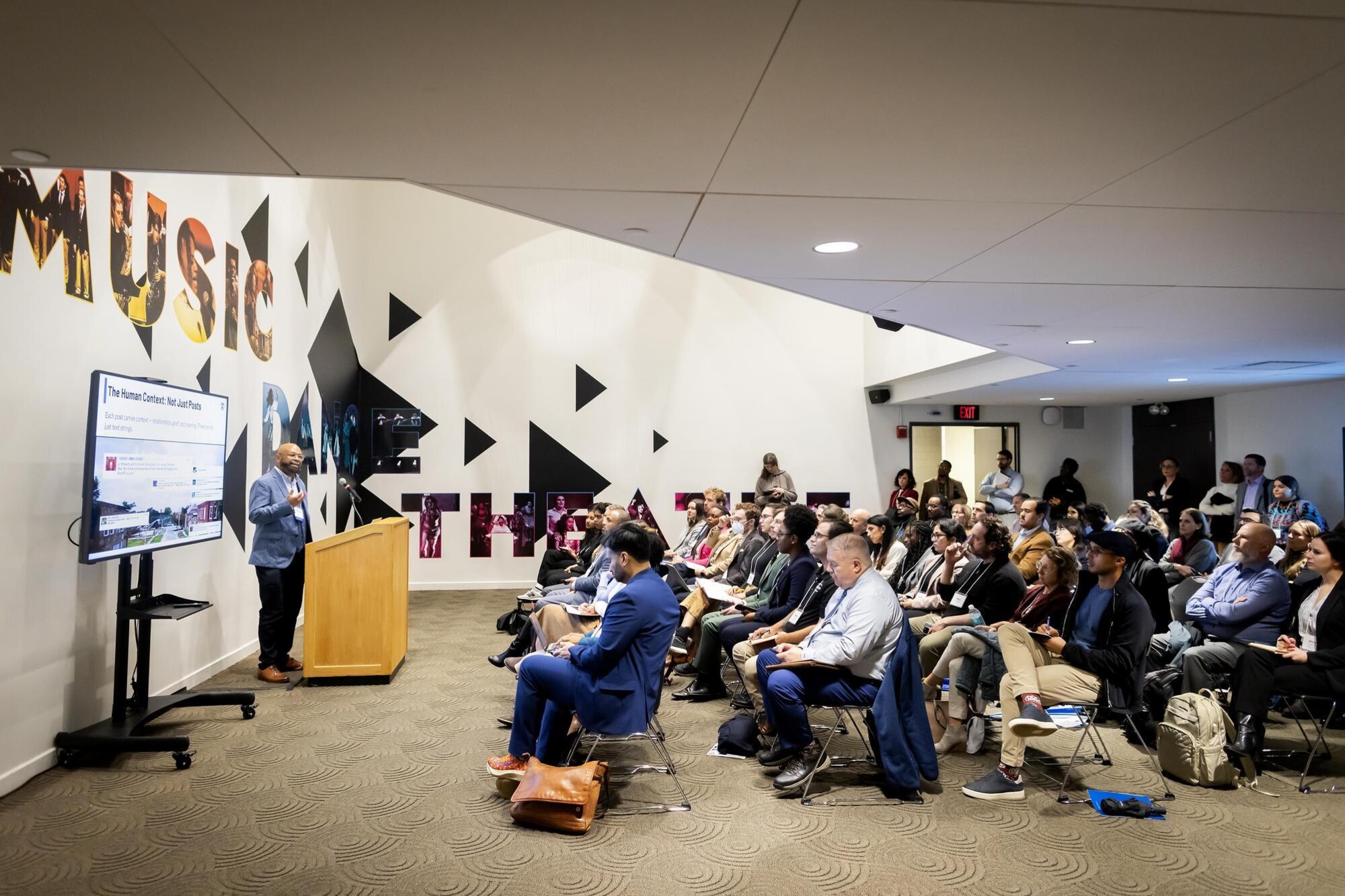 Desmond Patton speaking to a room of people at an AI conference.