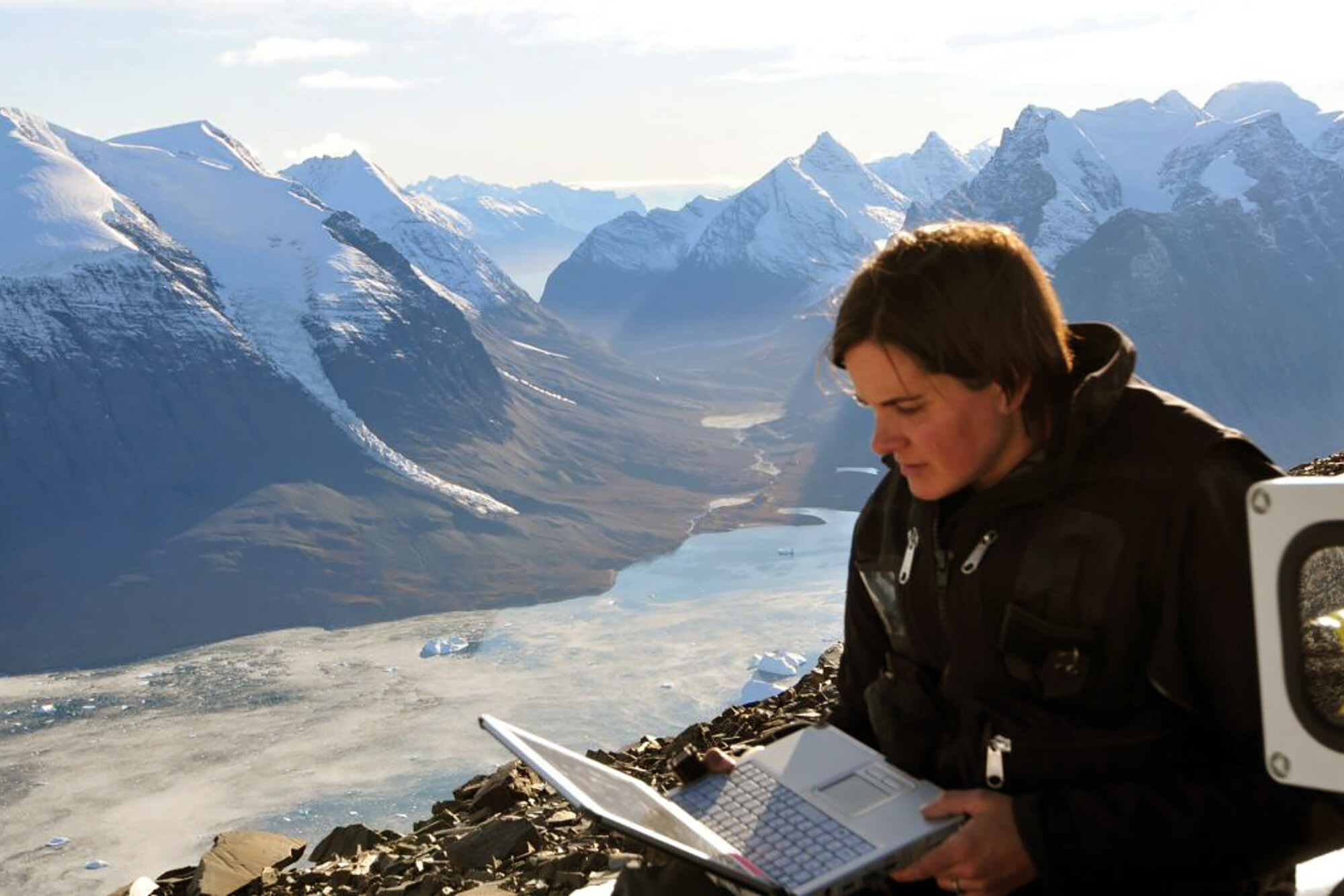 Leigh Stearns with a laptop observing a glacier.