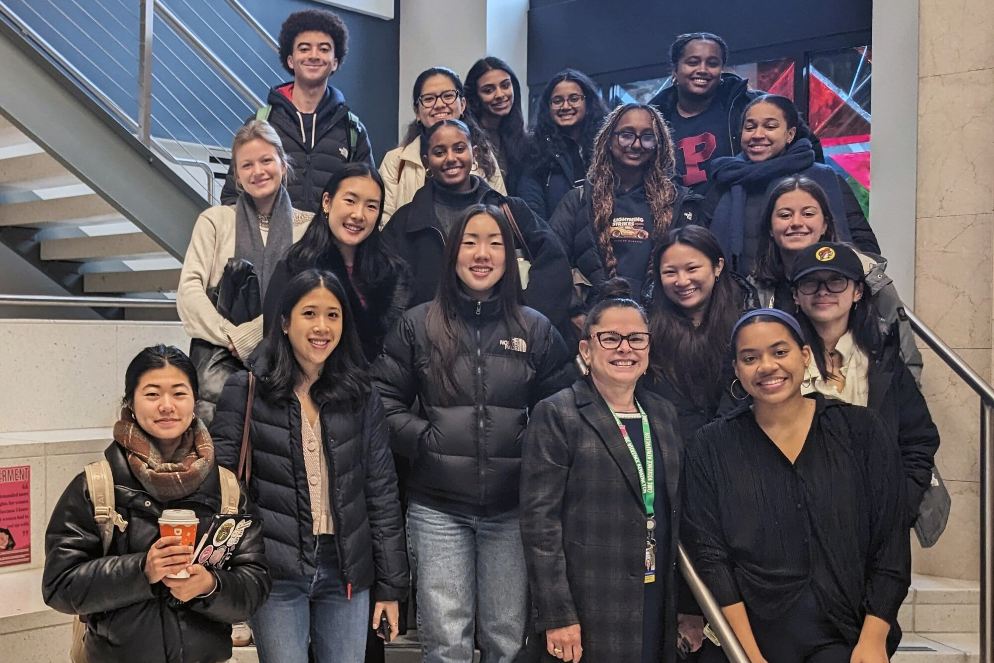 Penn students as a group on stairs during a visit to a community group.