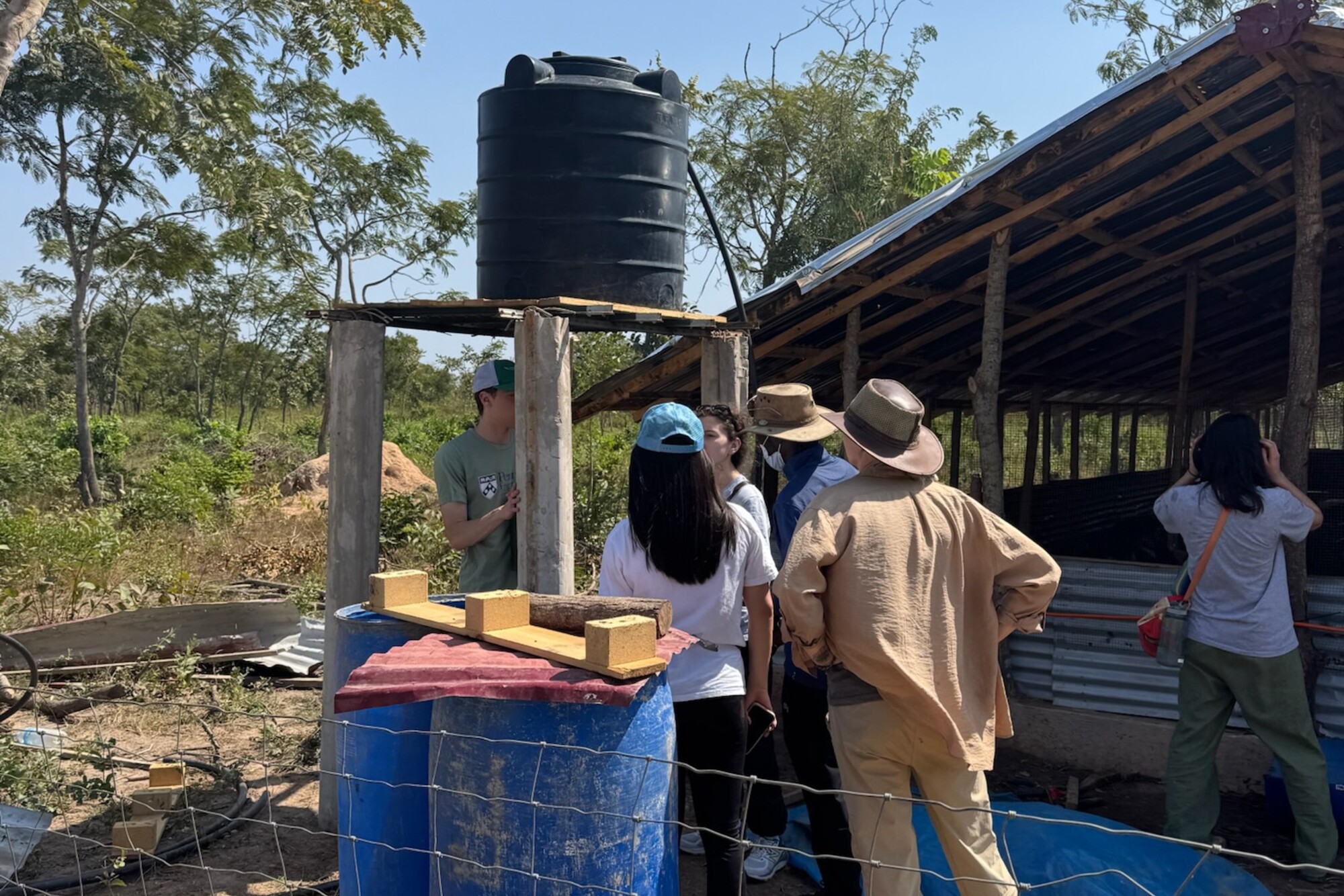 Workers and students gathered around a borehole for drinking water.