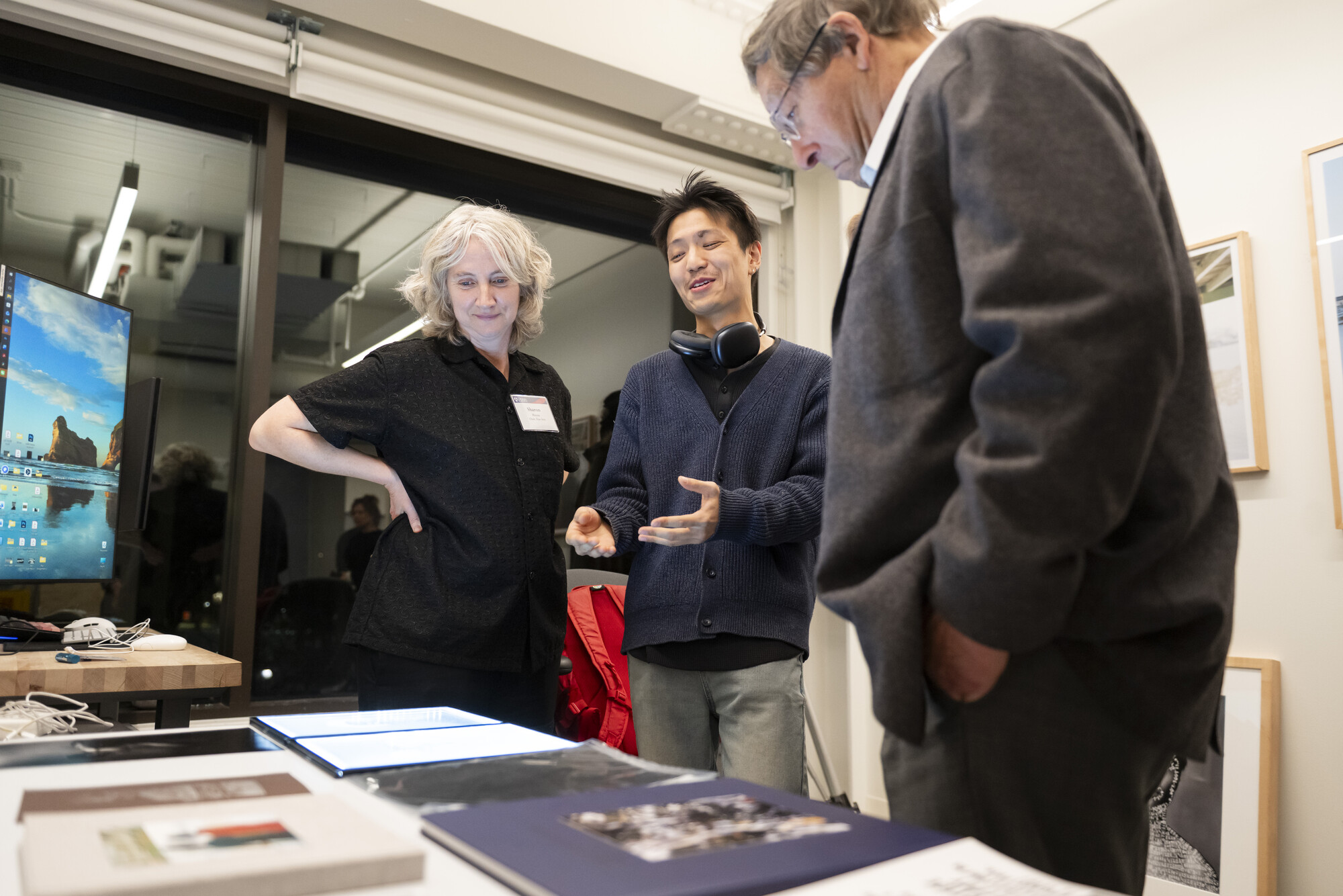Sharon Hayes, a Weitzman student, and Stuart Weitzman looking at books on a table.