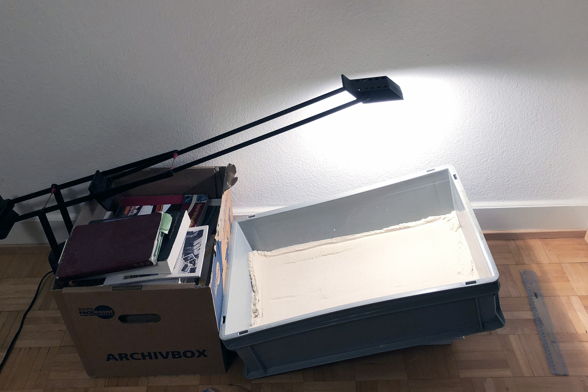 A small ramp in a box lit by an overhead lamp.