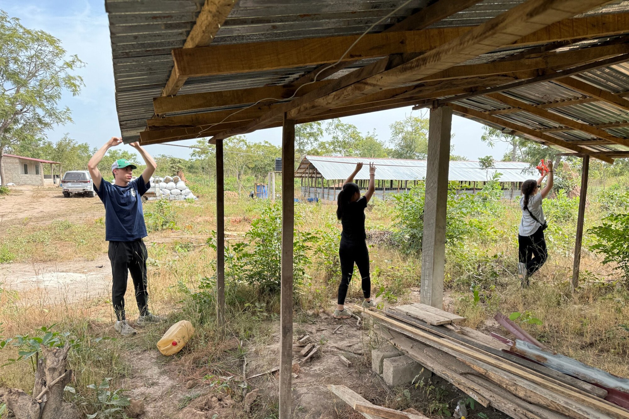 Jack, Iris, and Laila measuring a shed in Gambia.