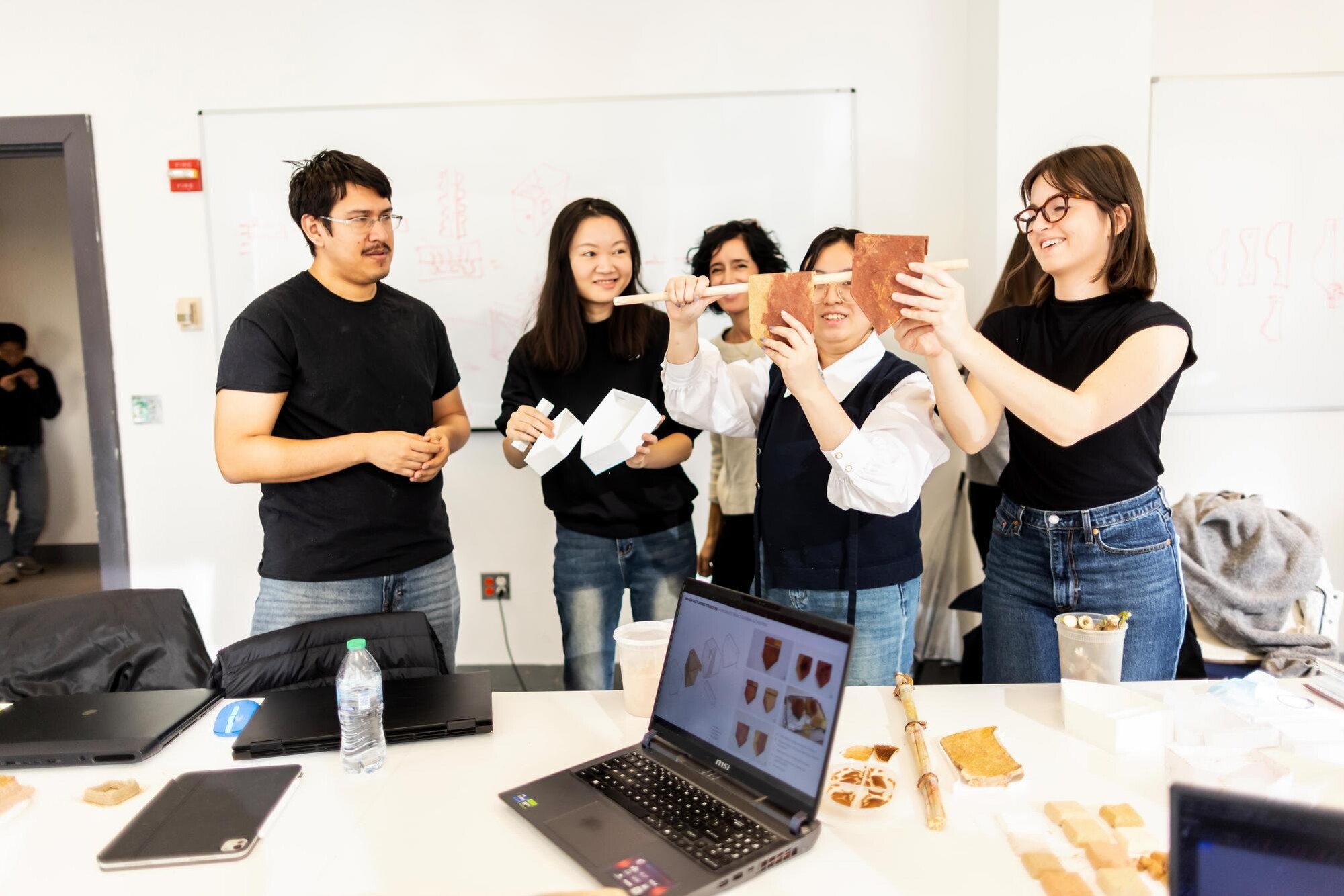 Four students and Laia Mogas-Soldevila working with food scraps in a lab.