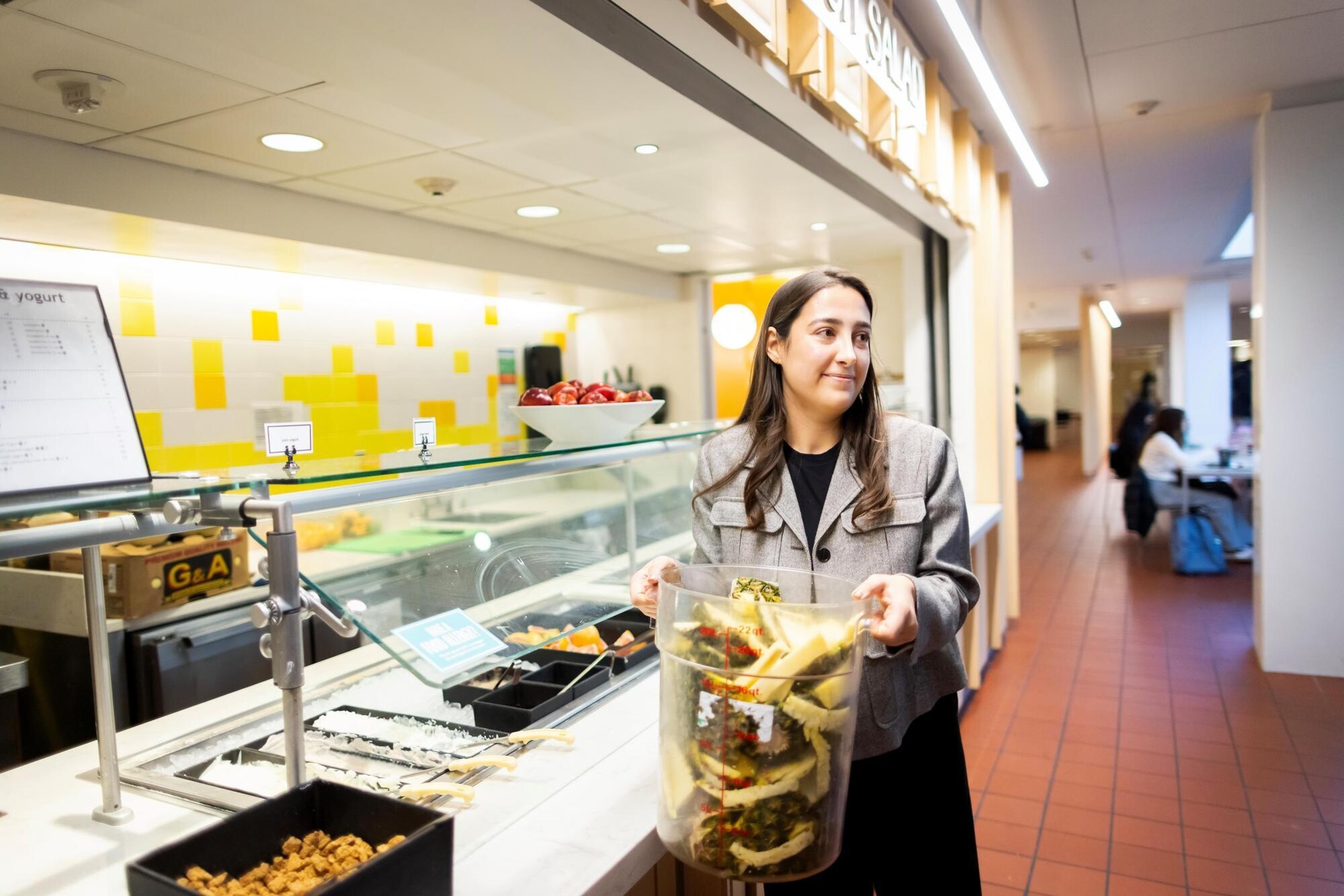 A person carrying a bucket of food scraps from Penn Dining.