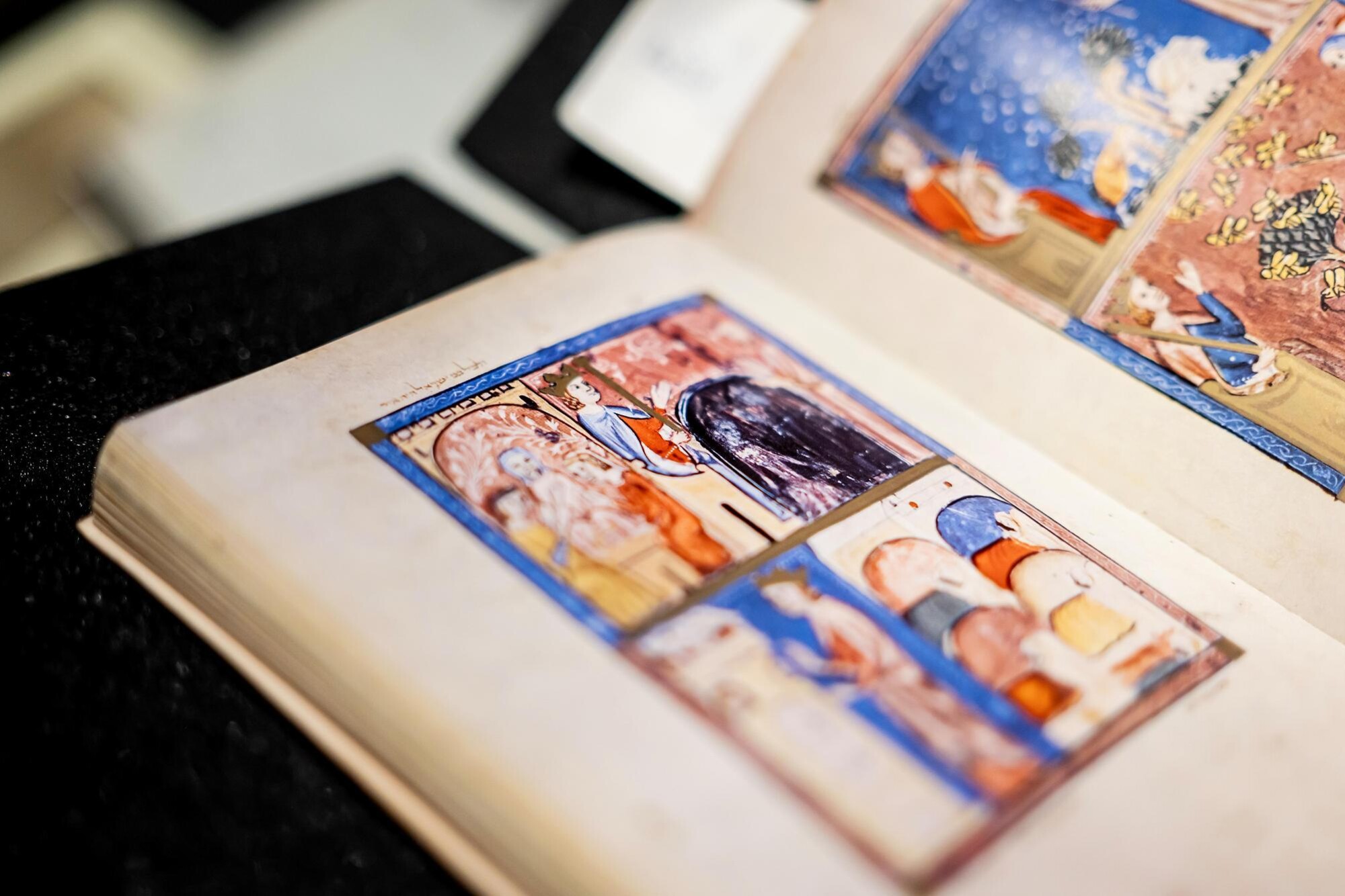 The Sarajevo Haggadah, up close and opened to a specific page featuring a vividly-colored illustration.