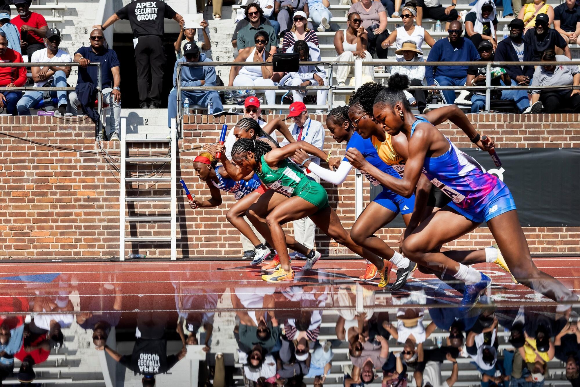 Runners starting a race on the track at Franklin Field during Penn Relays.
