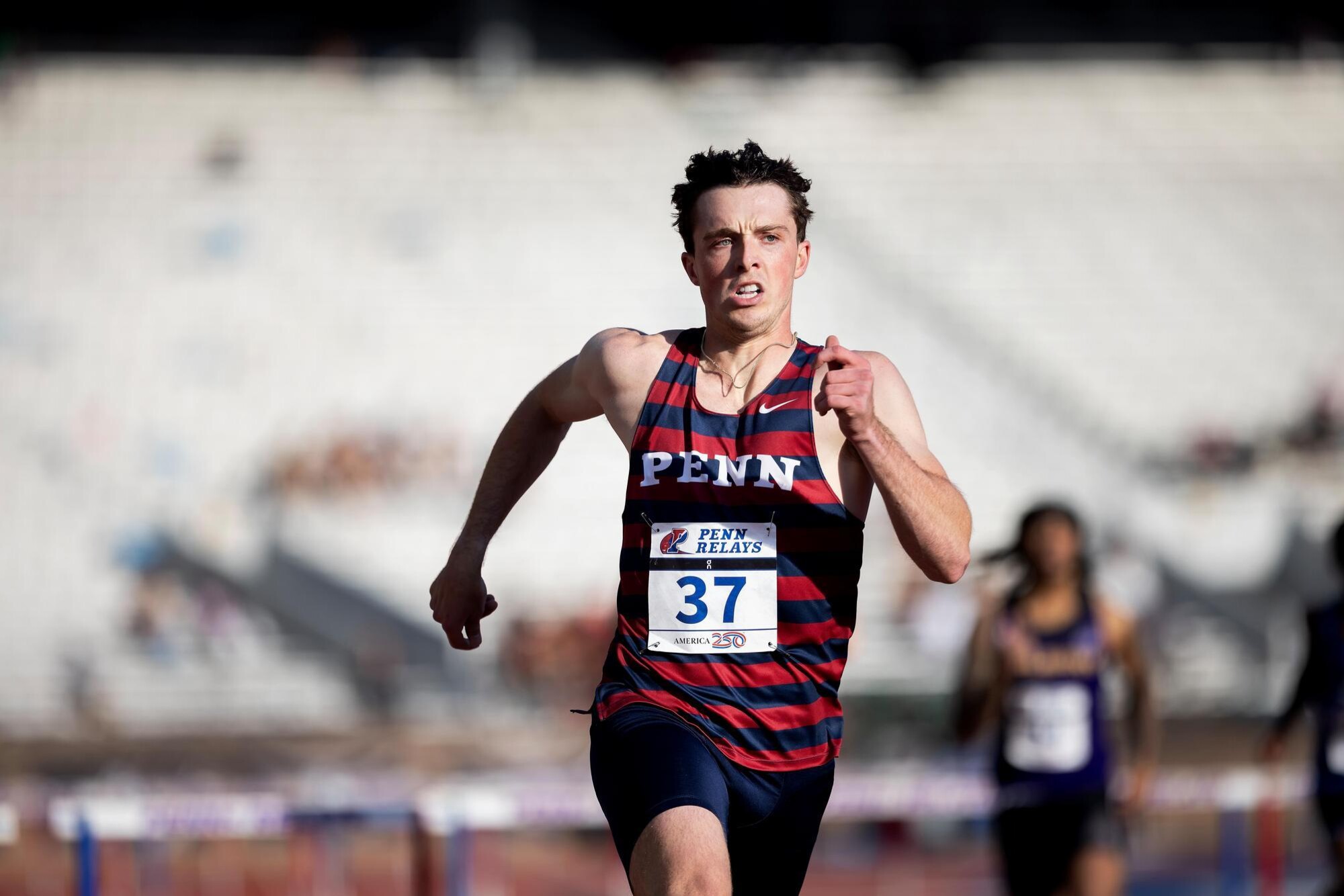 A runner on Franklin Field during Penn Relays