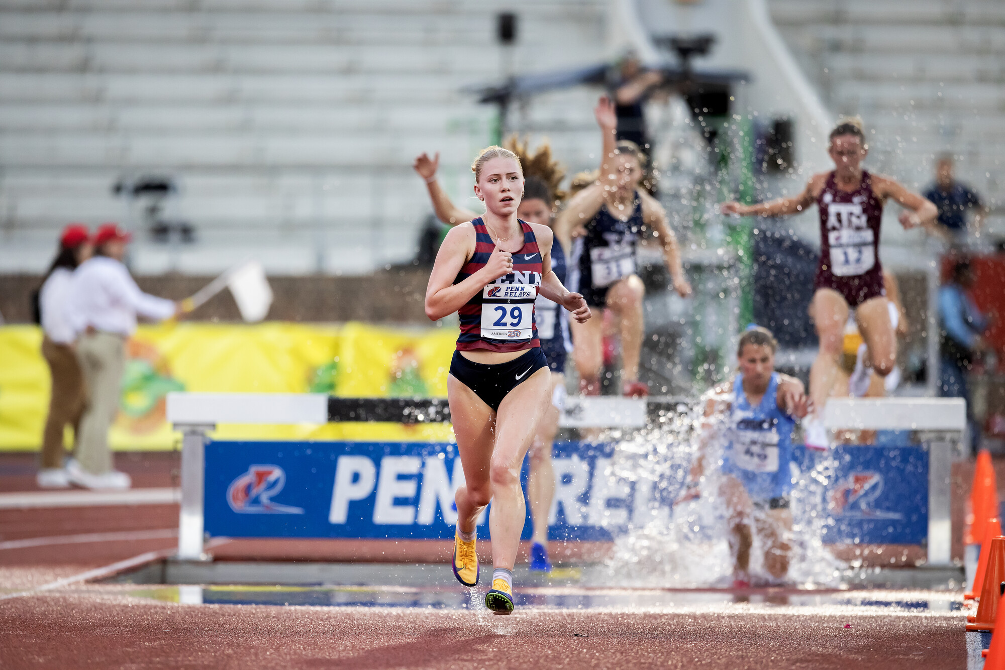 Runners on the track during the steeplechase on Franklin Field during the Penn Relays