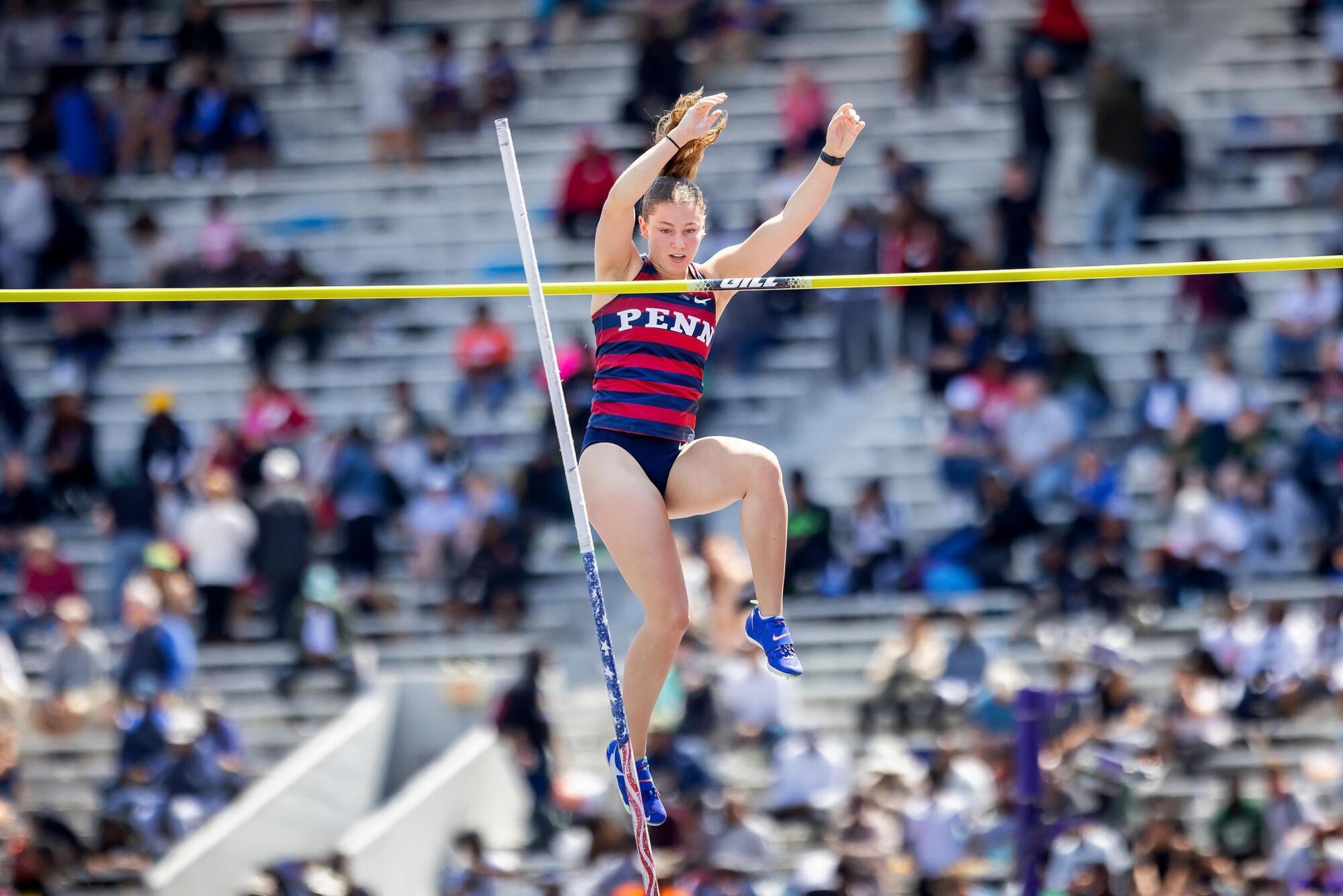 A pole vaulter descending in air.