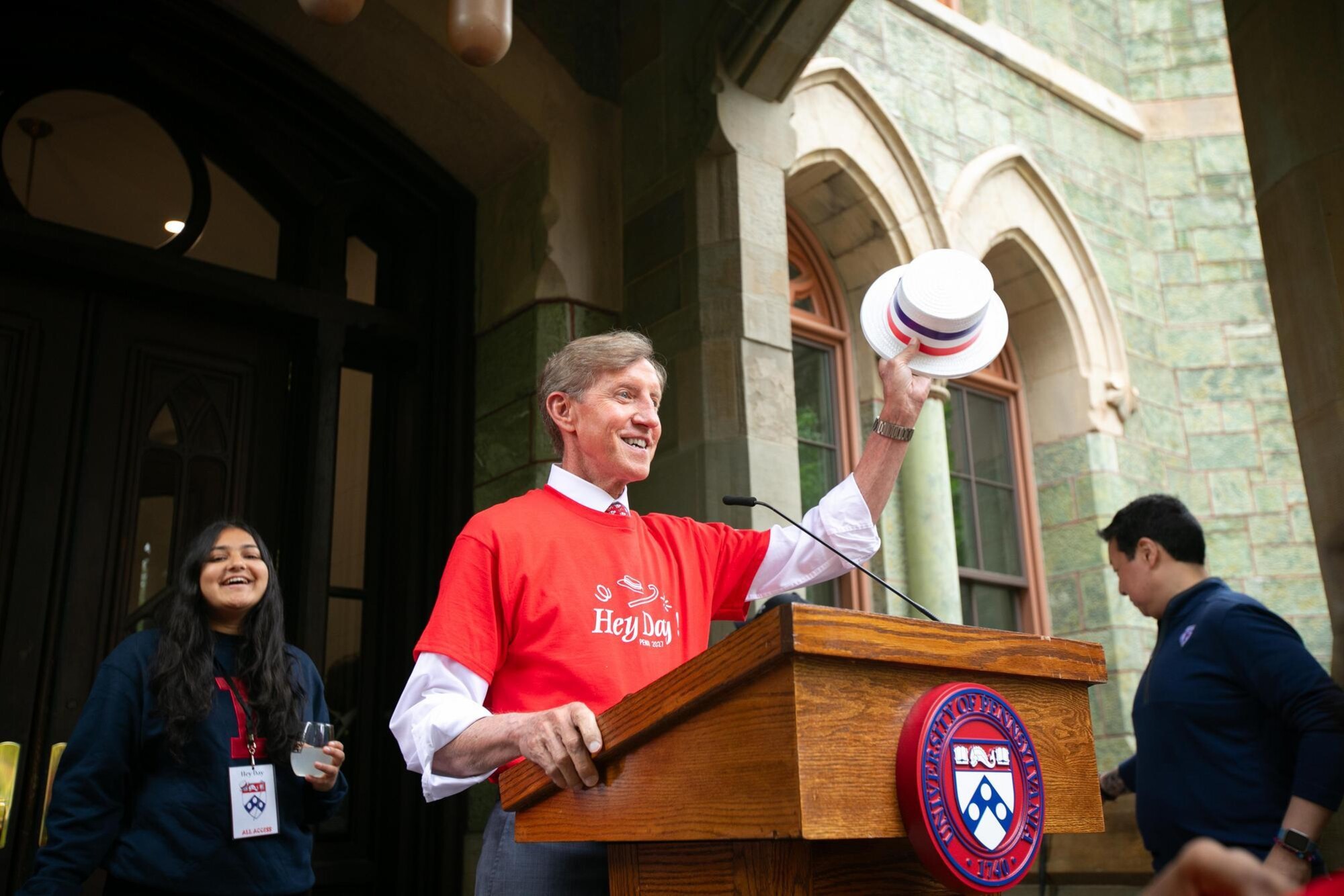 J. Larry Jameson holding his Hey Day hat aloft on the steps of College Hall during Hey Day.