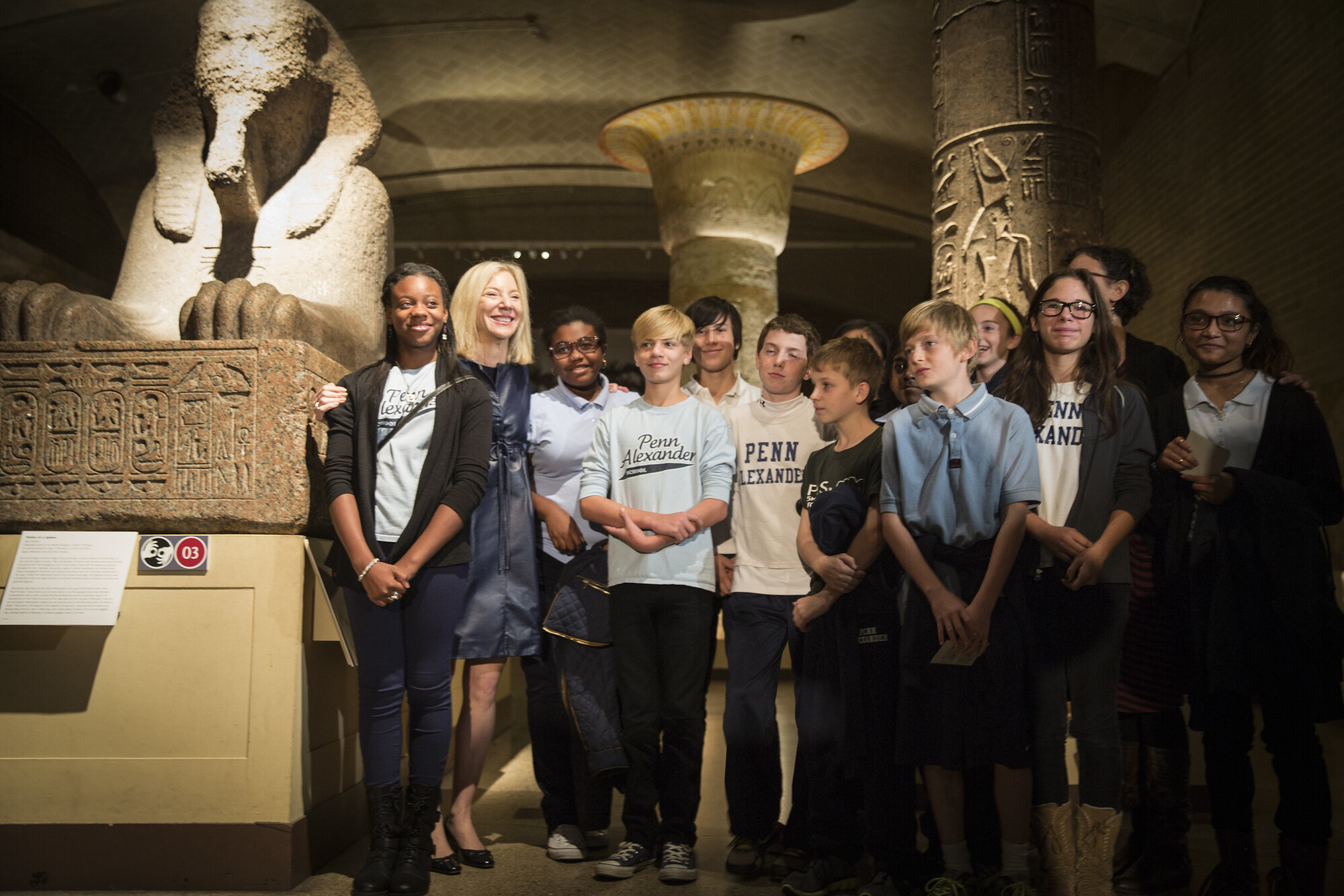 Amy Gutmann standing in the Penn Museum with a group of young students from the Penn Alexander School.