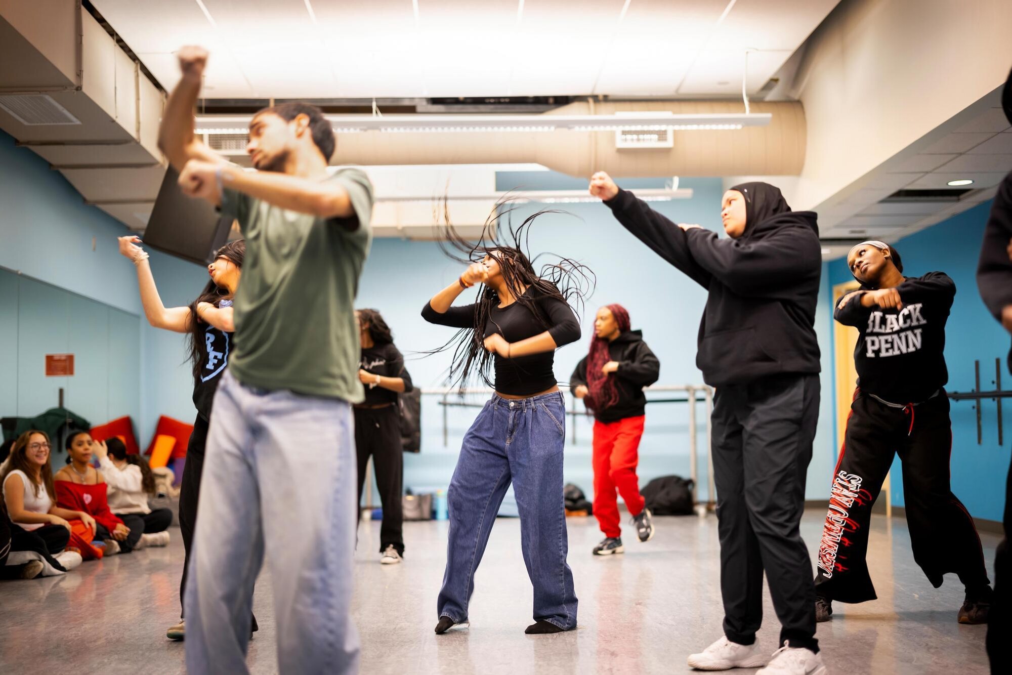 Students in the Strictly Funk group dancing in unison. In the middle, one student's long hair is pictured in motion.