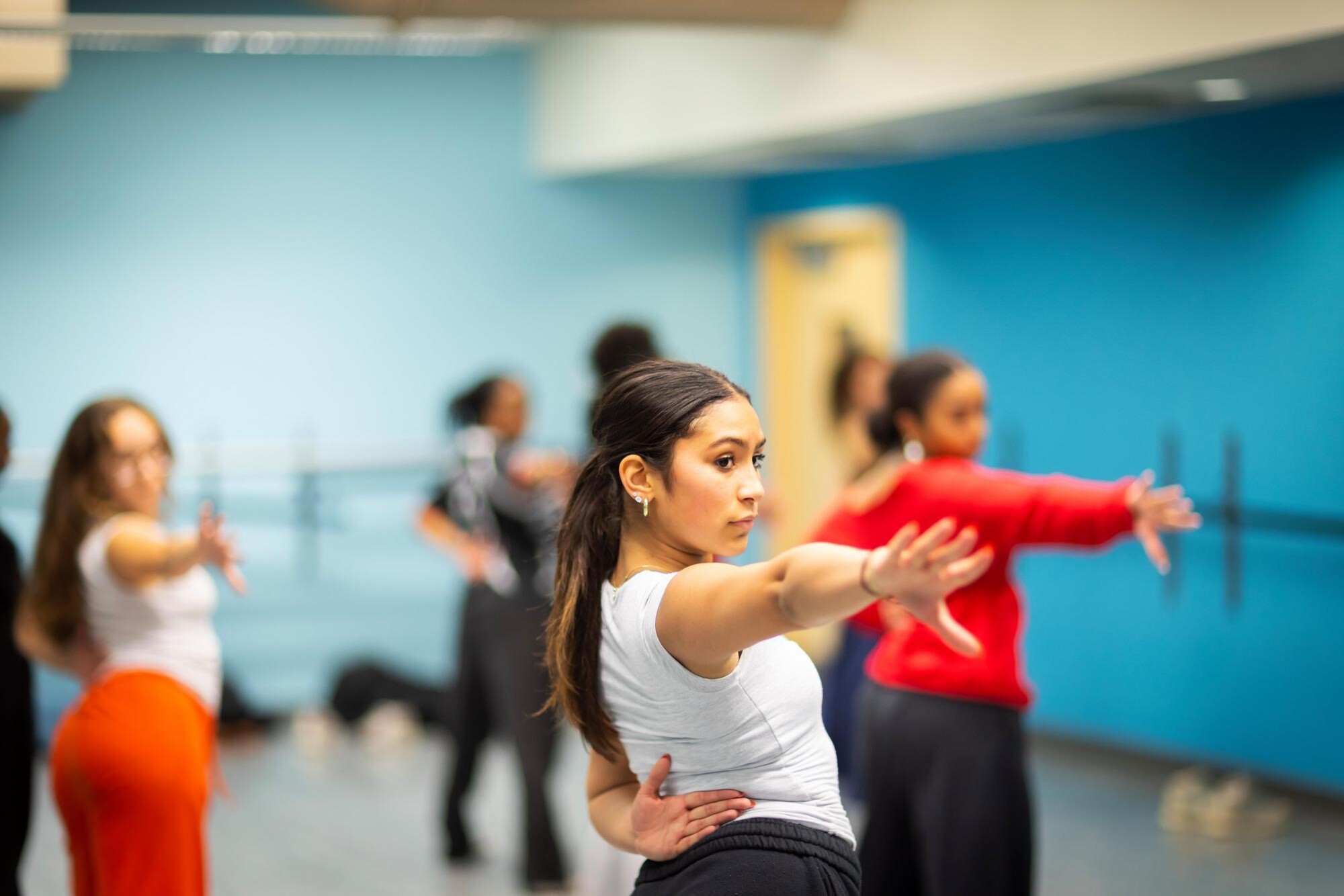A student in the Strictly Funk group facing forward with a focused look, and extending her arm and fingers