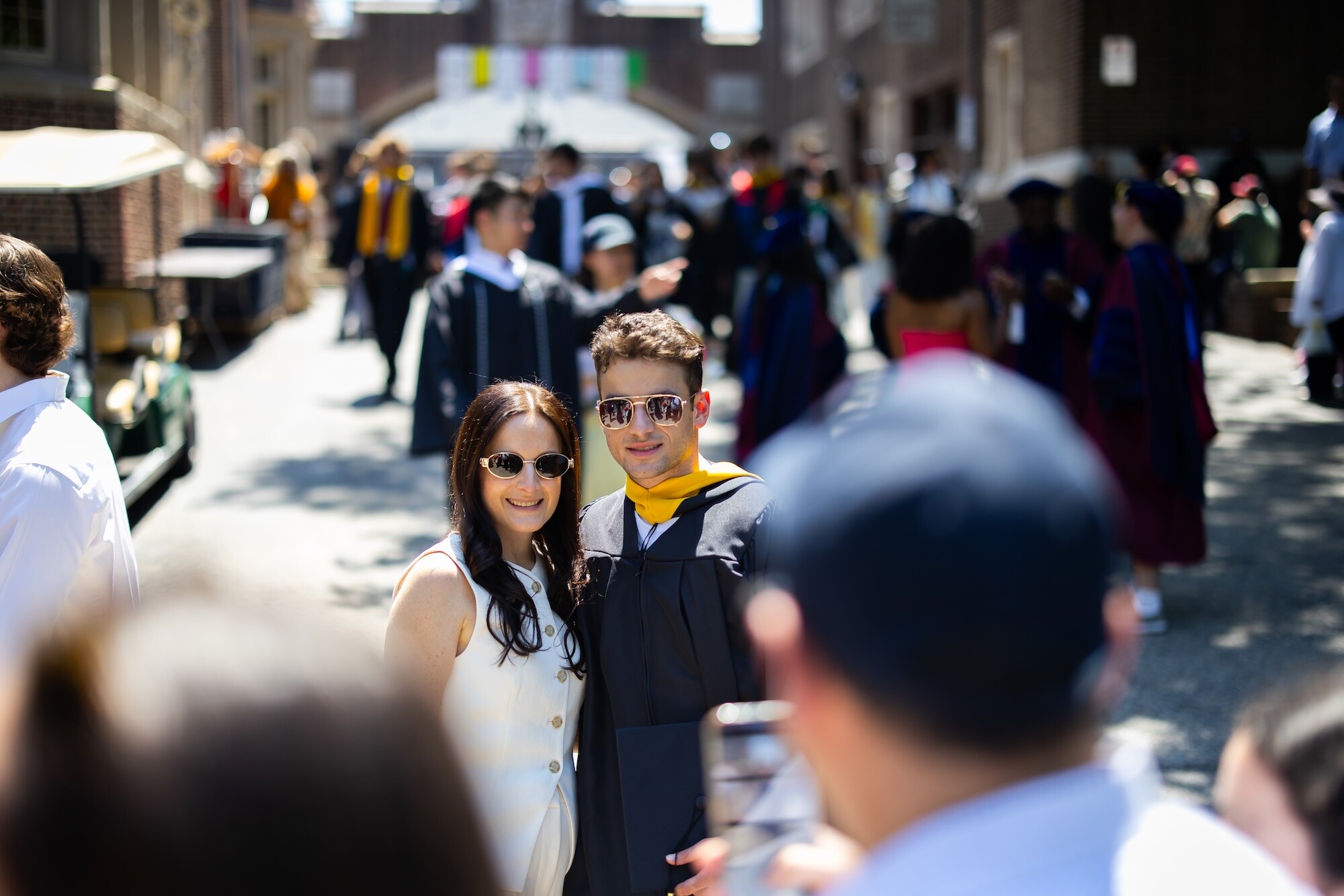 A grad posing with their parent for a photo at Commencement.