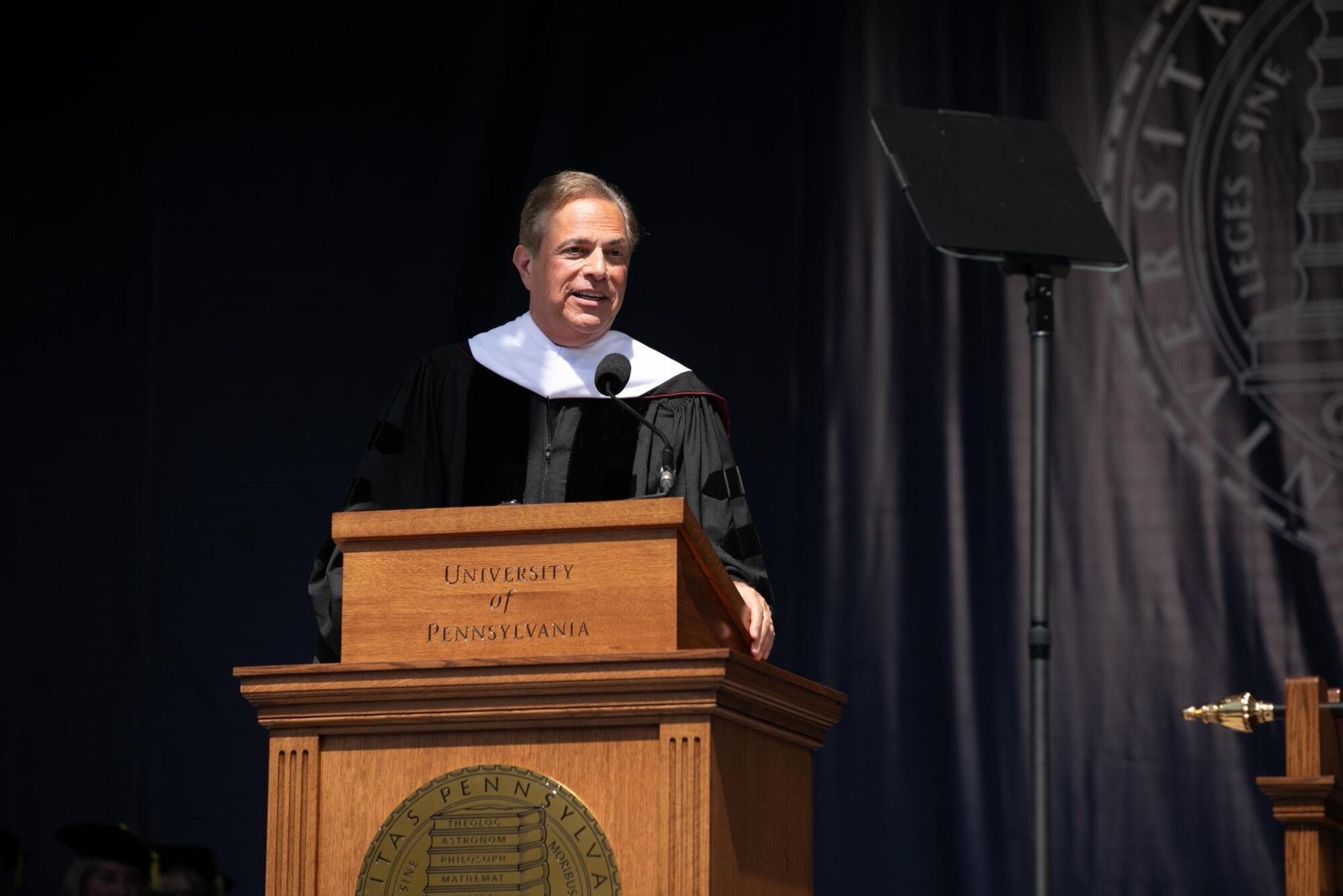 Michael Beschloss speaking at the podium during commencement.