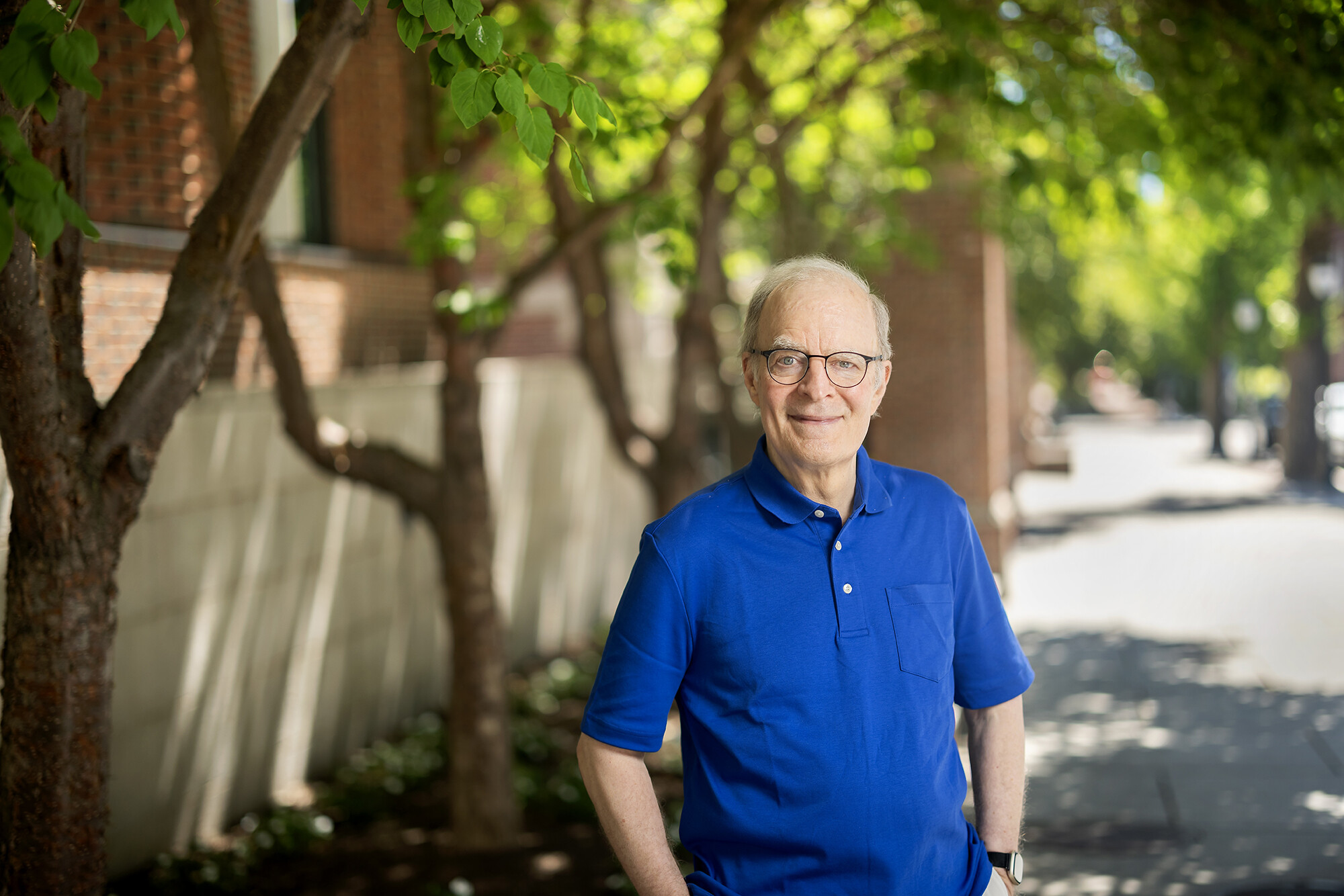 William Ewald standing on sidewalk with greenery behind
