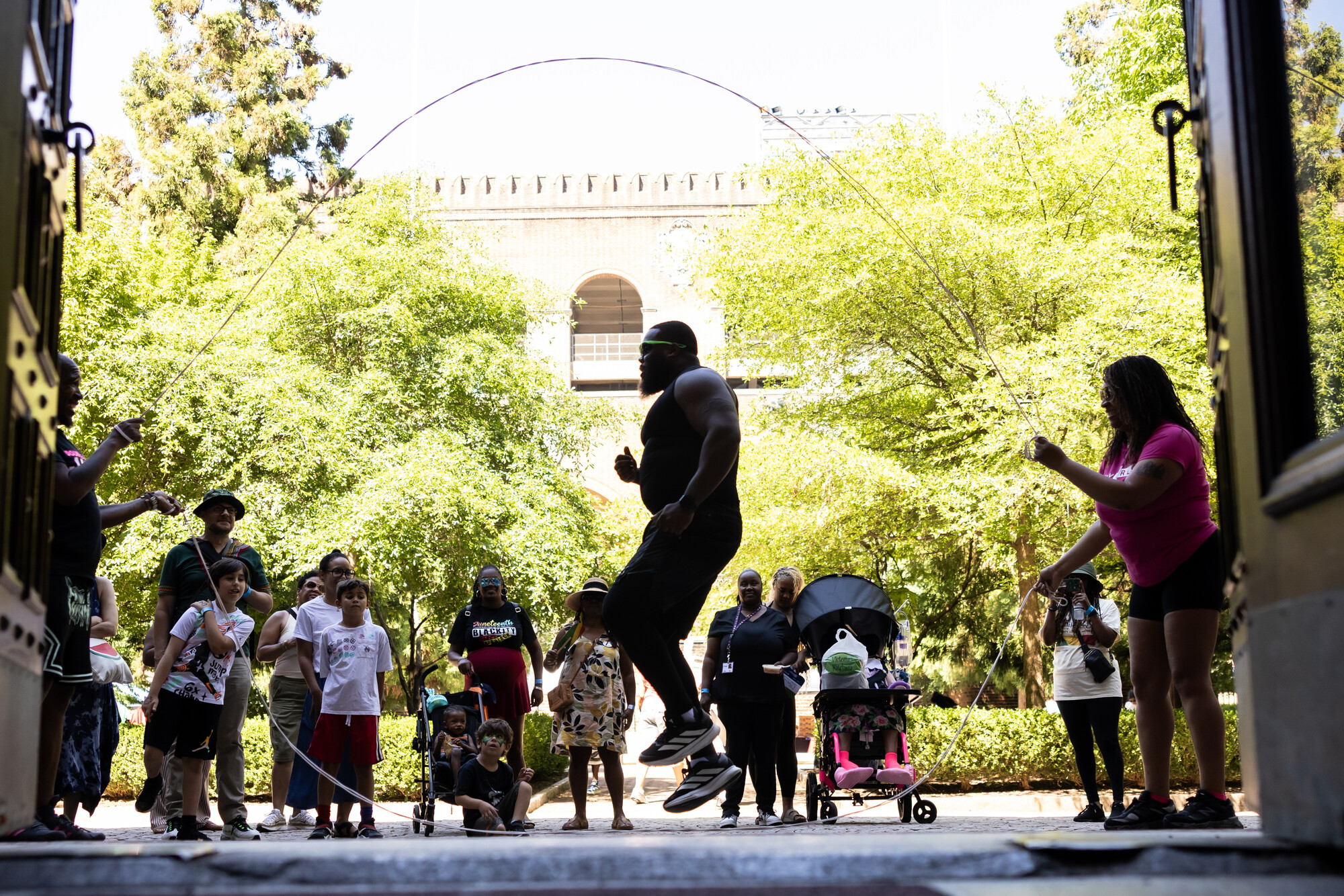 A person jumping in the double dutch ropes on the Penn Museum courtyard.