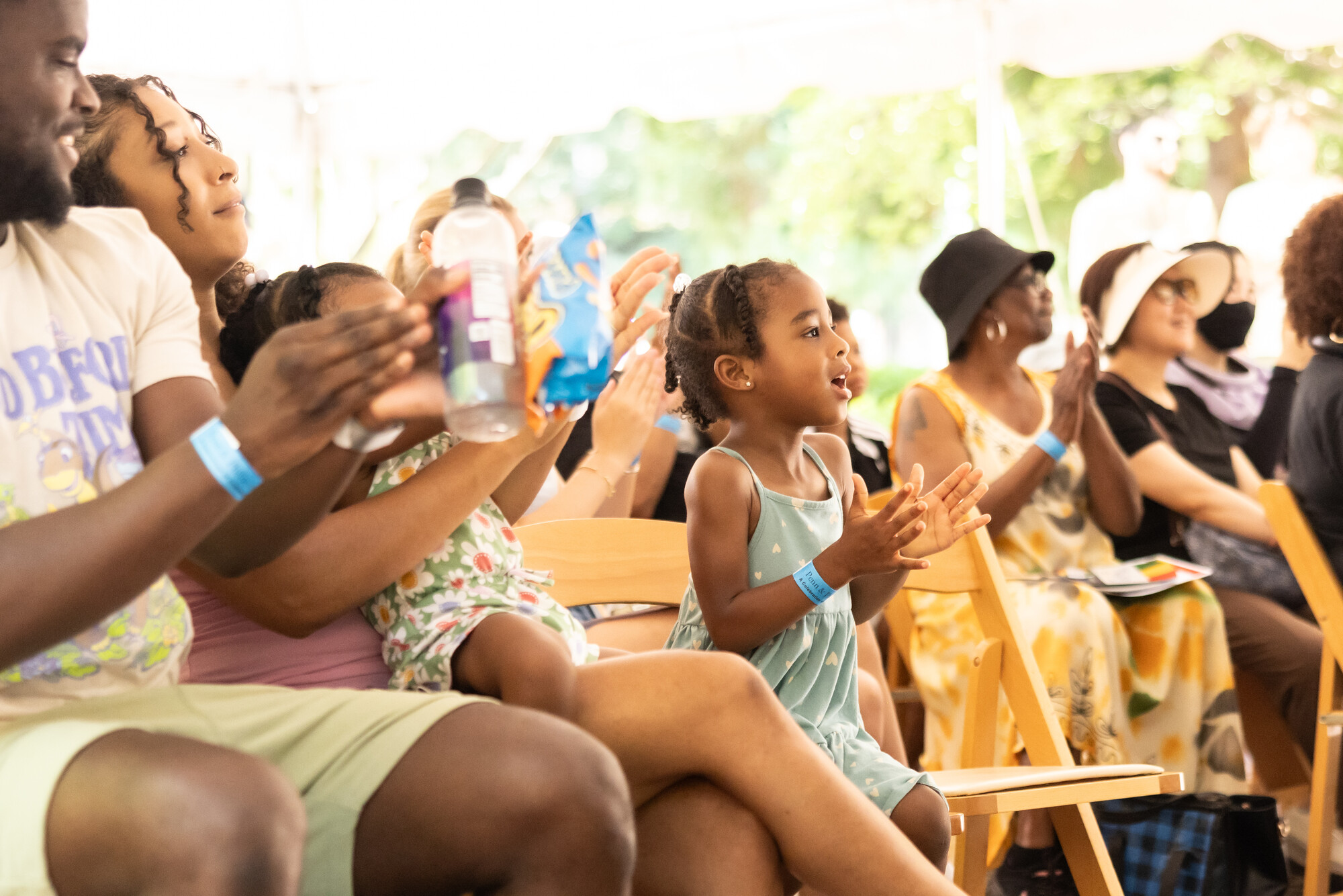 Kids and families clapping in the audience at the Juneteenth celebration.