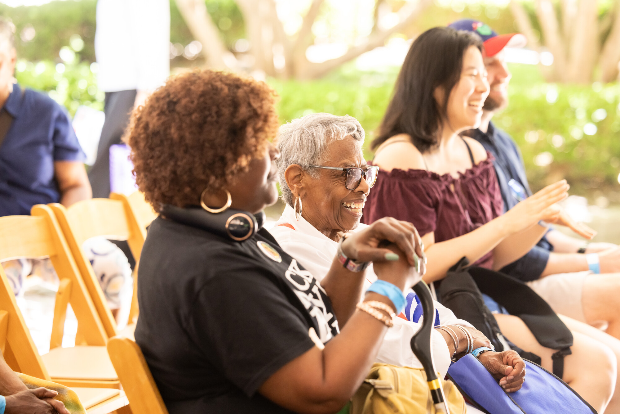 Three people watching a Juneteenth performance at the Penn Museum courtyard.