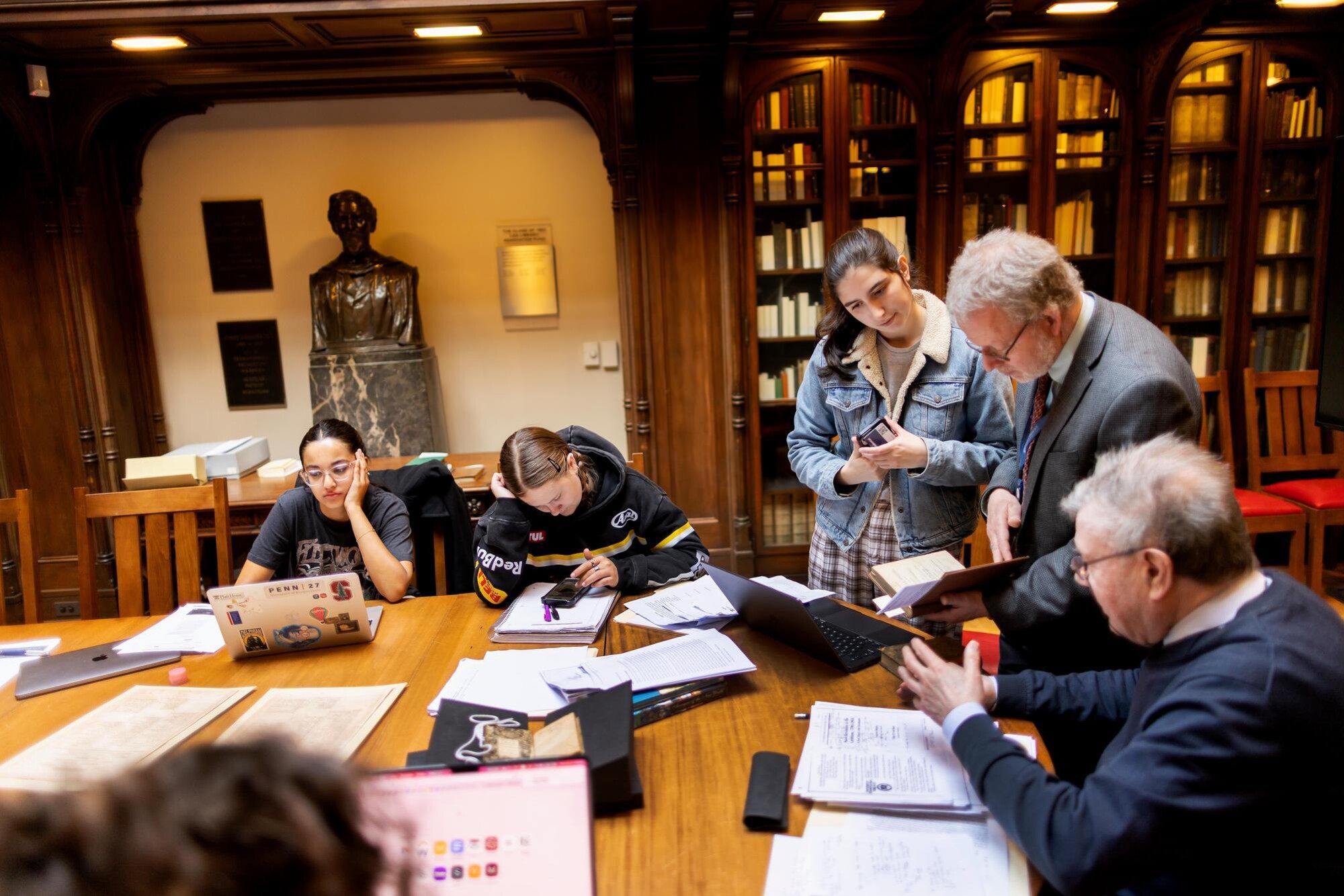 Faculty talk with students about books in the Lea Library