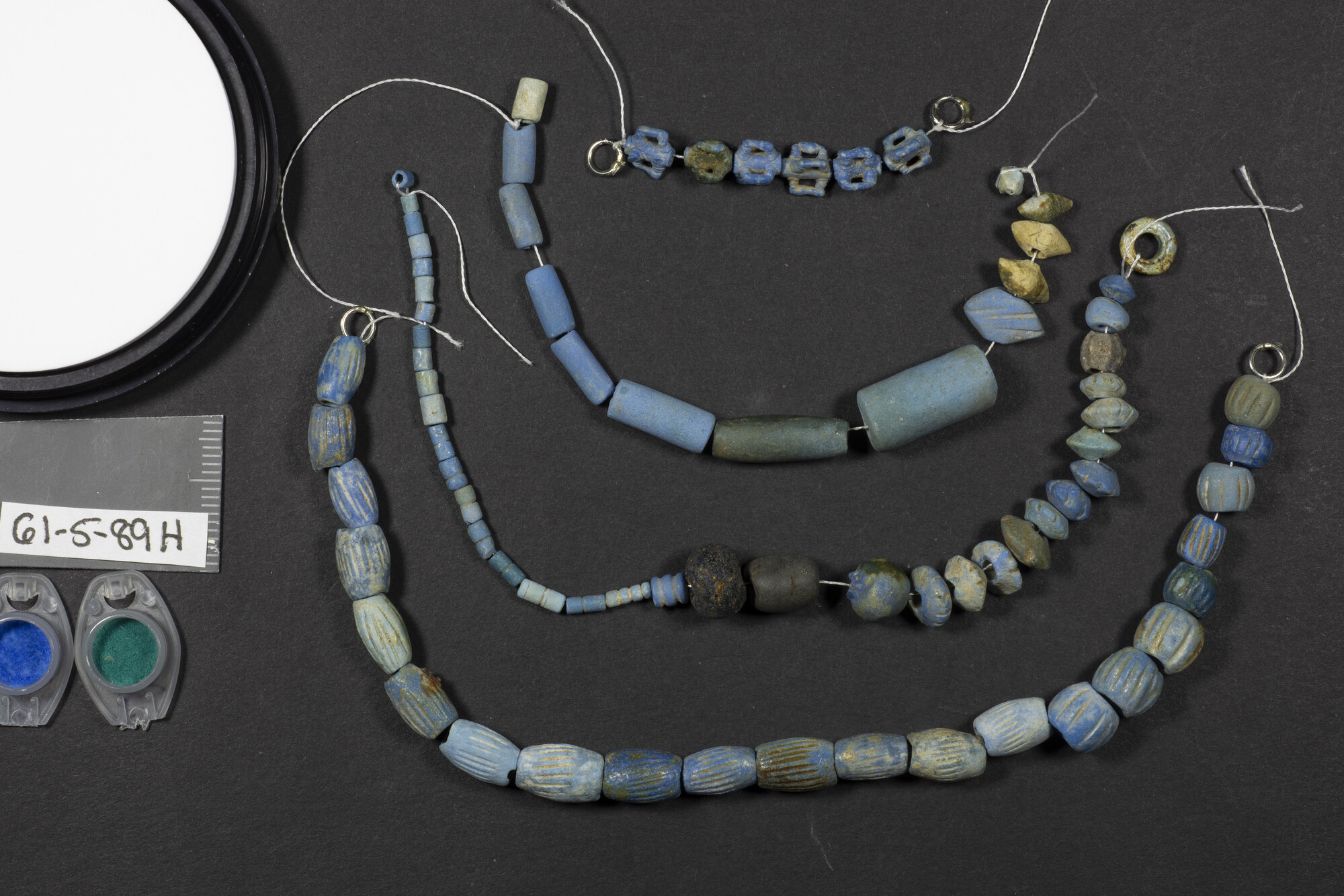 A bead necklace with some beads molded from Egyptian blue photographed in visible light.