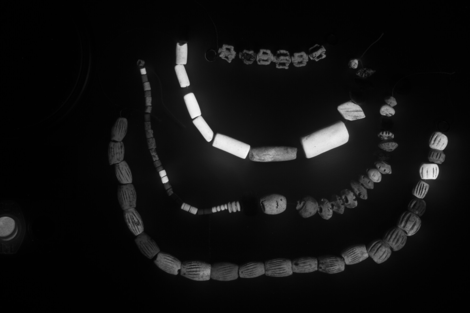 A bead necklace with some Egyptian blue beads showing hows the pigment luminesces using Visible-induced Infrared Luminescence (VIL) photography. 