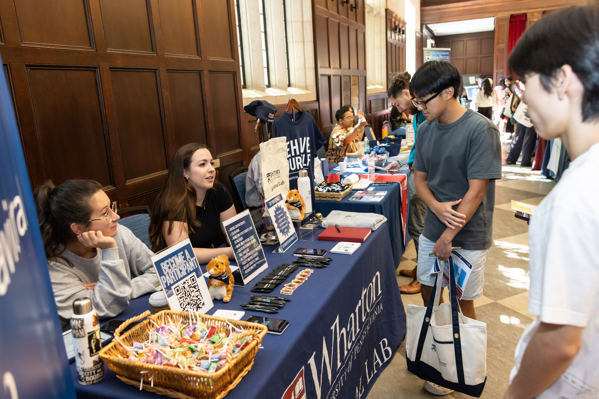 Penn students visiting information tables at a resource fair in Houston Hall.