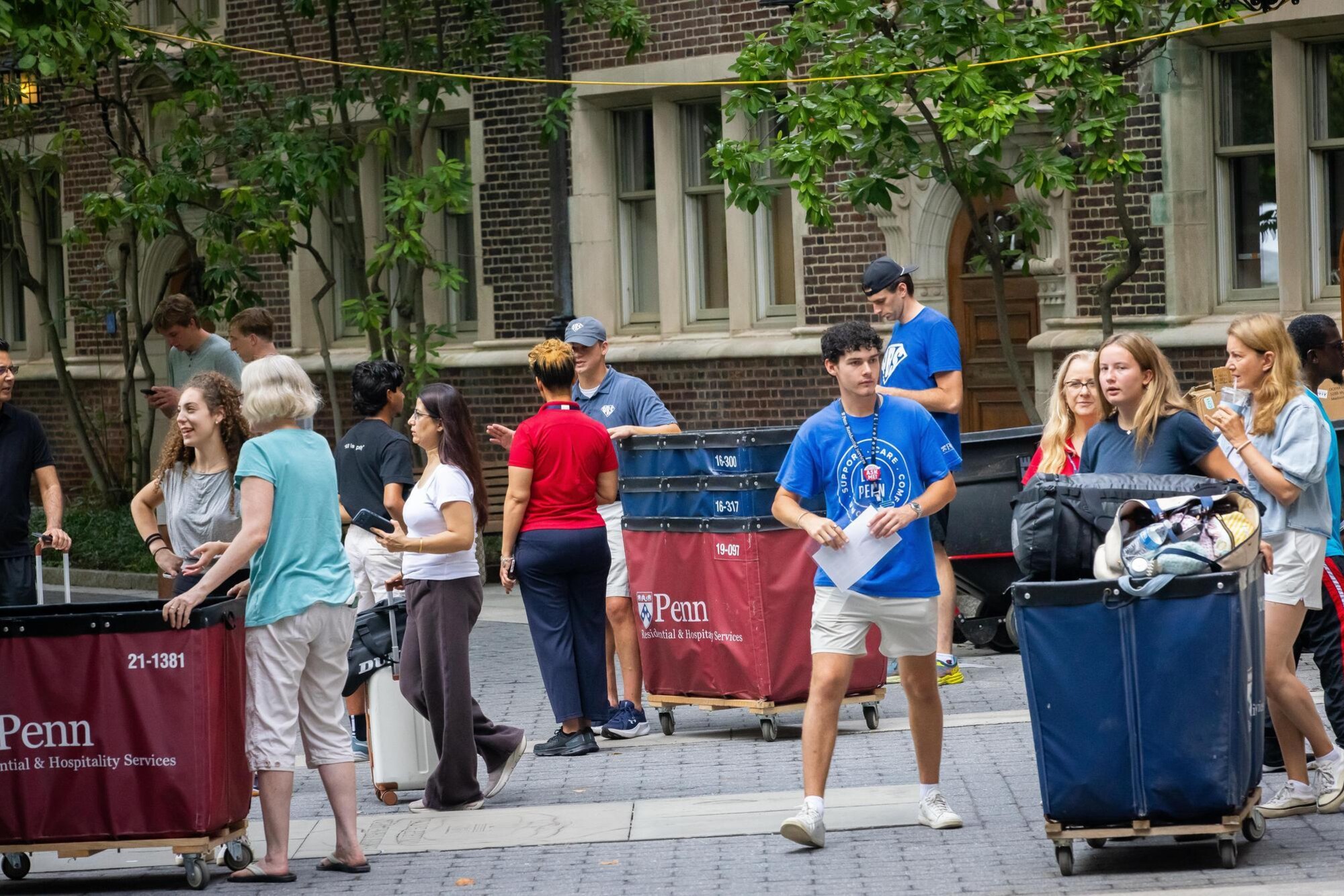 Students, parents, and move-in staff with carts outside the Quad during Move-In.