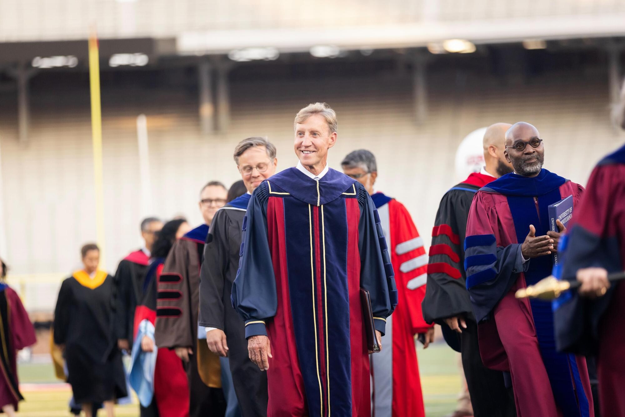 Penn President and Provost in procession onto Franklin Field in regalia.