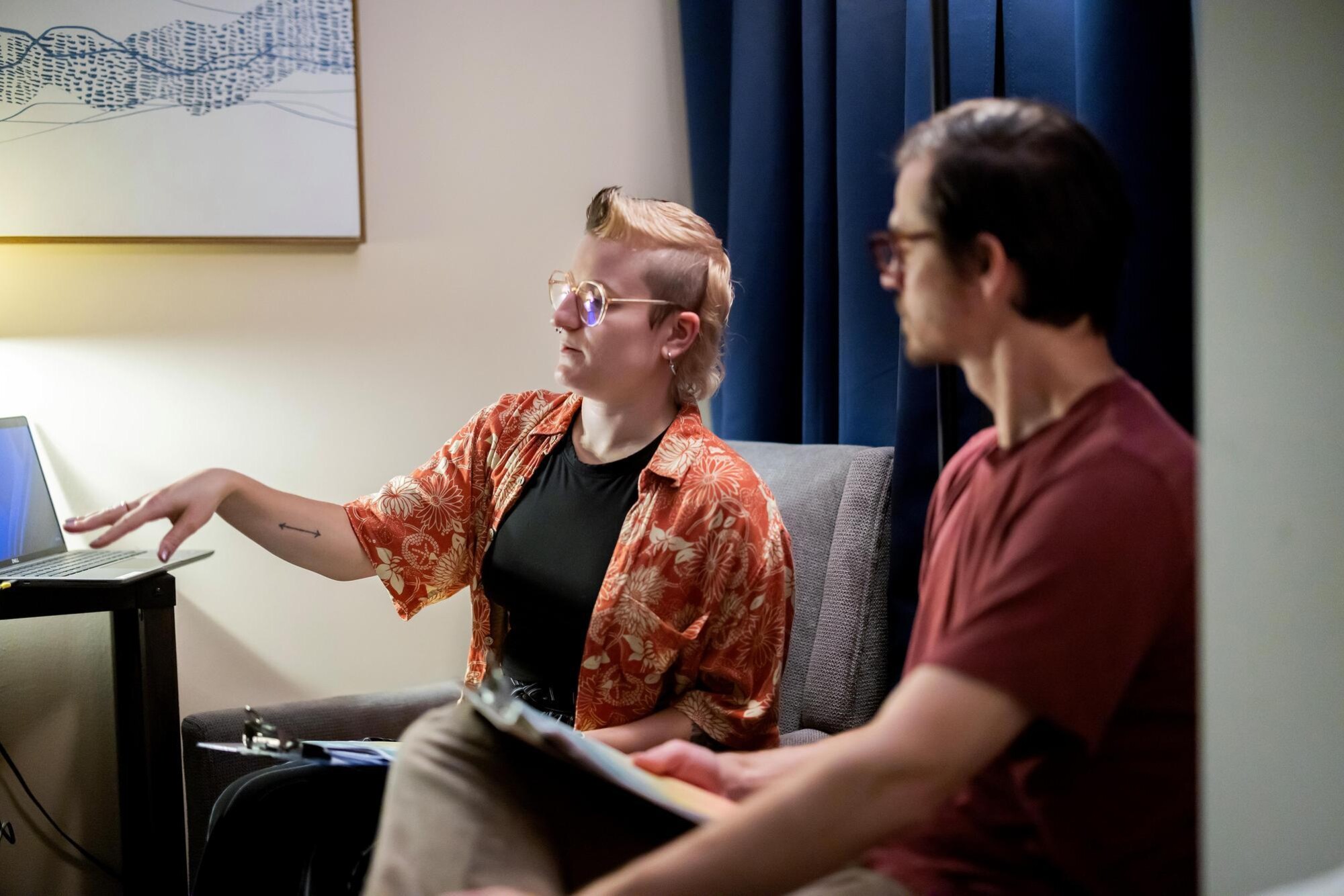 Klaudia Glogowaska and Paul Regier sit on couch.