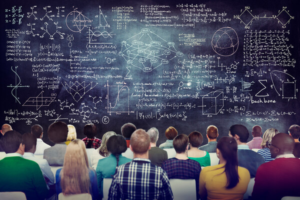 students-facing-a-blackboard-covered-in-complex-math-equations